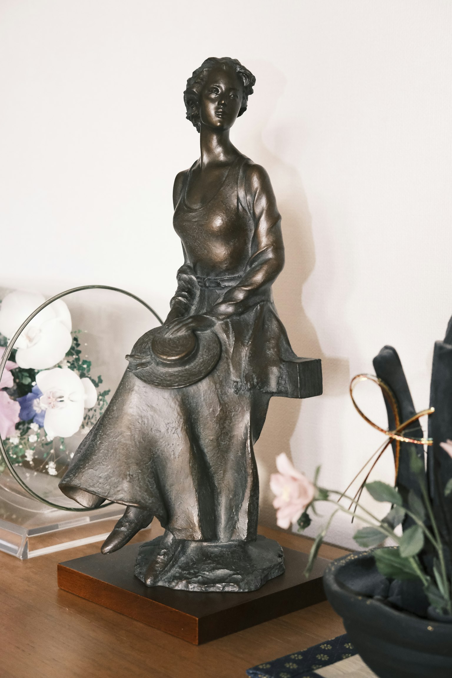 Eine bronzene Skulptur einer elegant sitzenden Frau auf einem Tisch