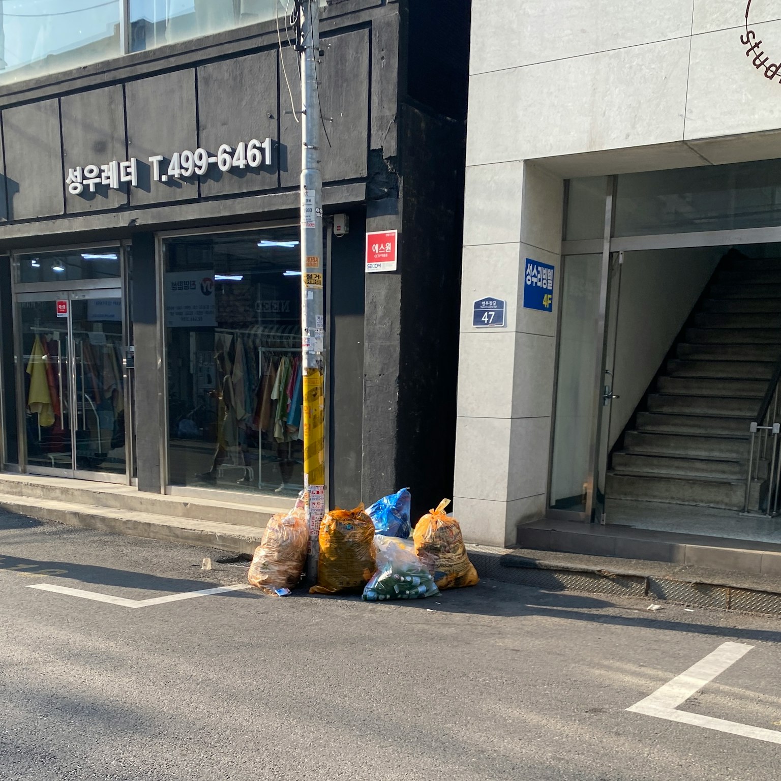 Sampah yang ditumpuk di jalan di samping toko pakaian