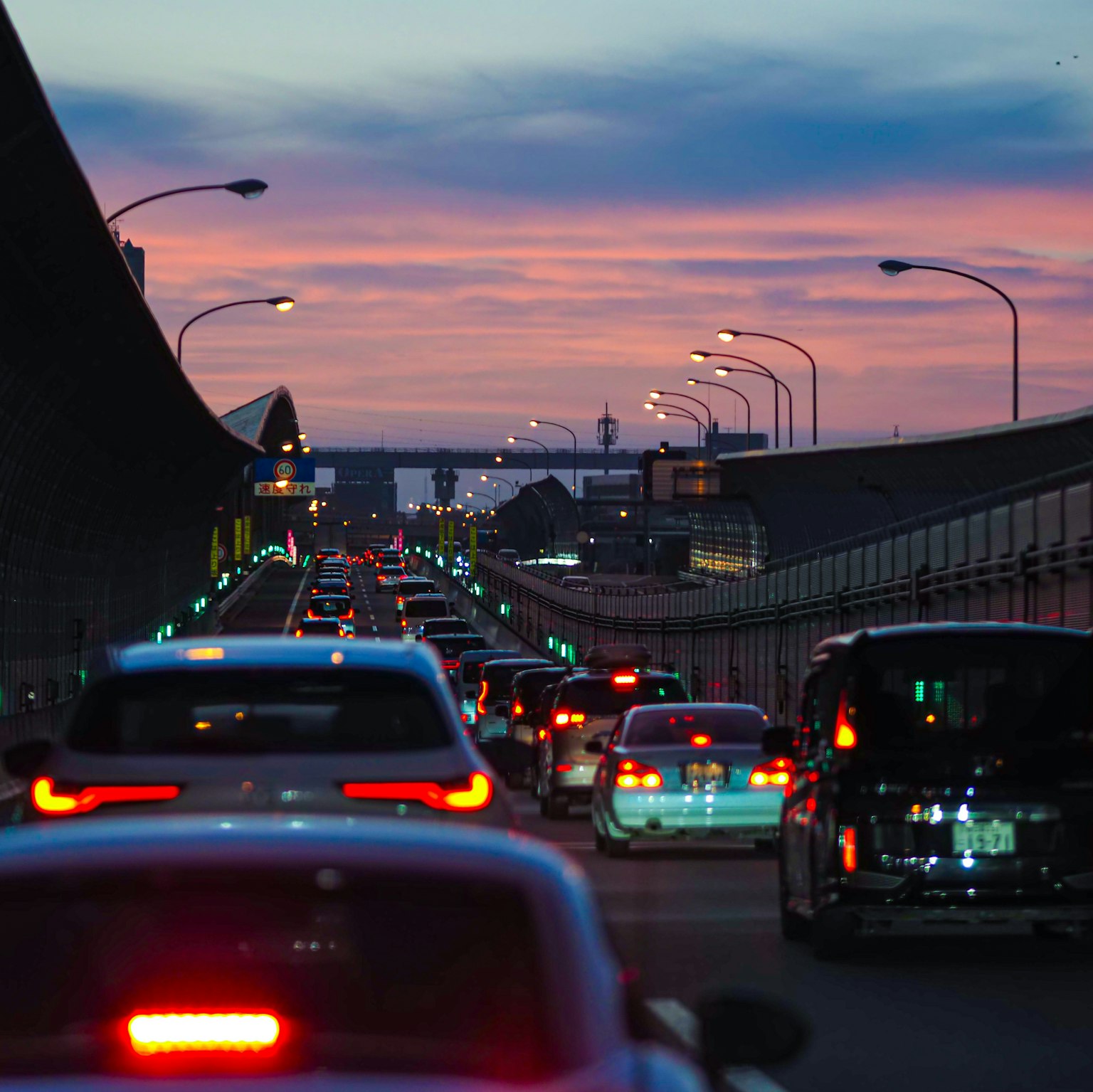 夕焼けの空を背景にした渋滞中の車両の列
