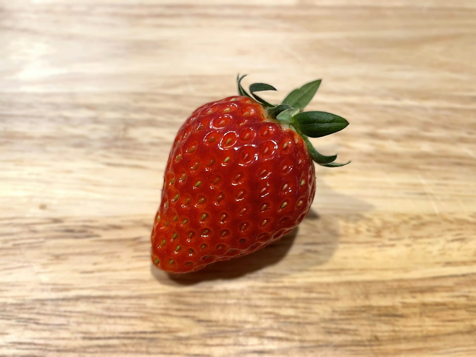 Vibrant red strawberry on a wooden table