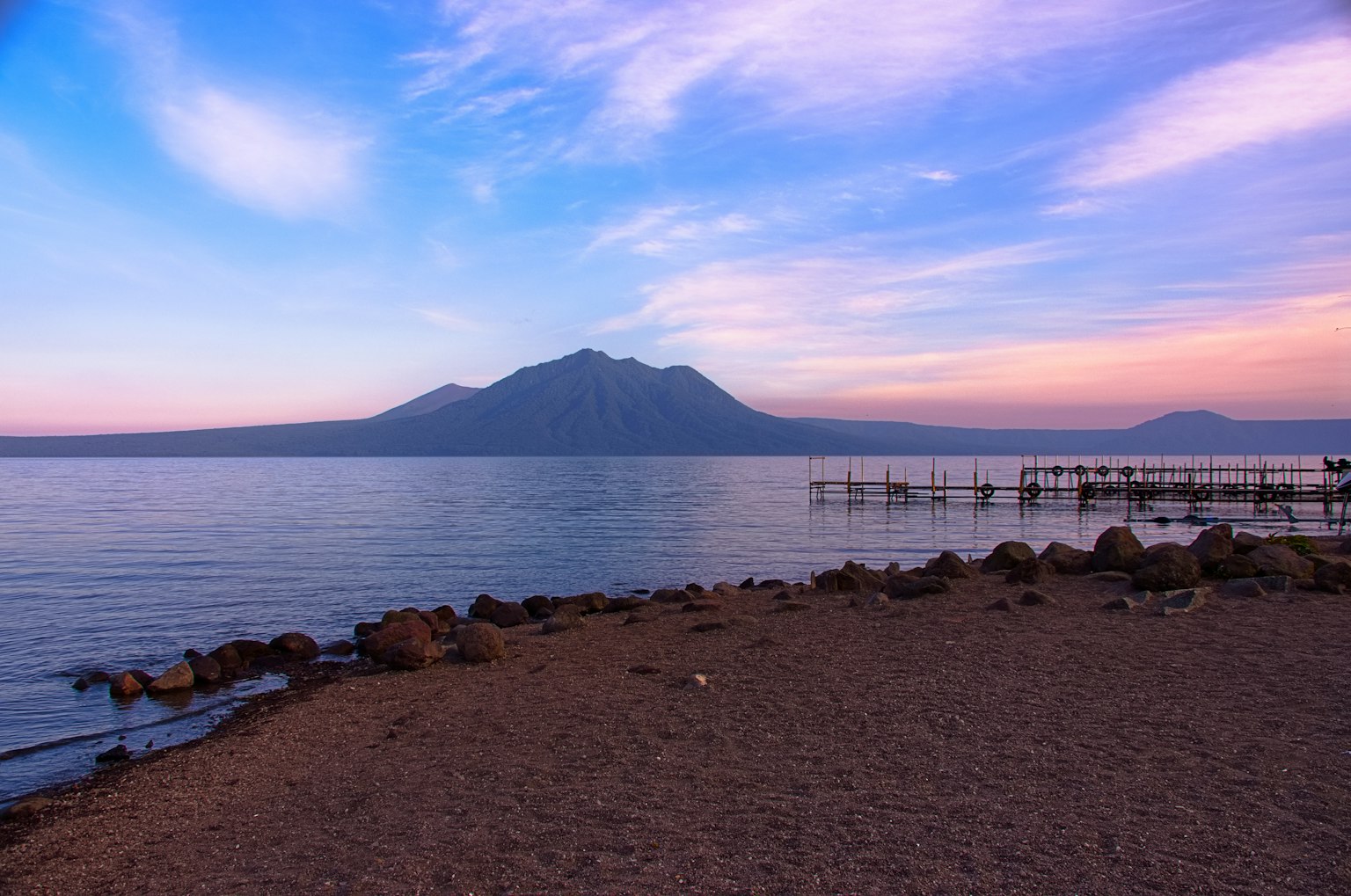 Pemandangan danau yang tenang dengan langit berwarna-warni