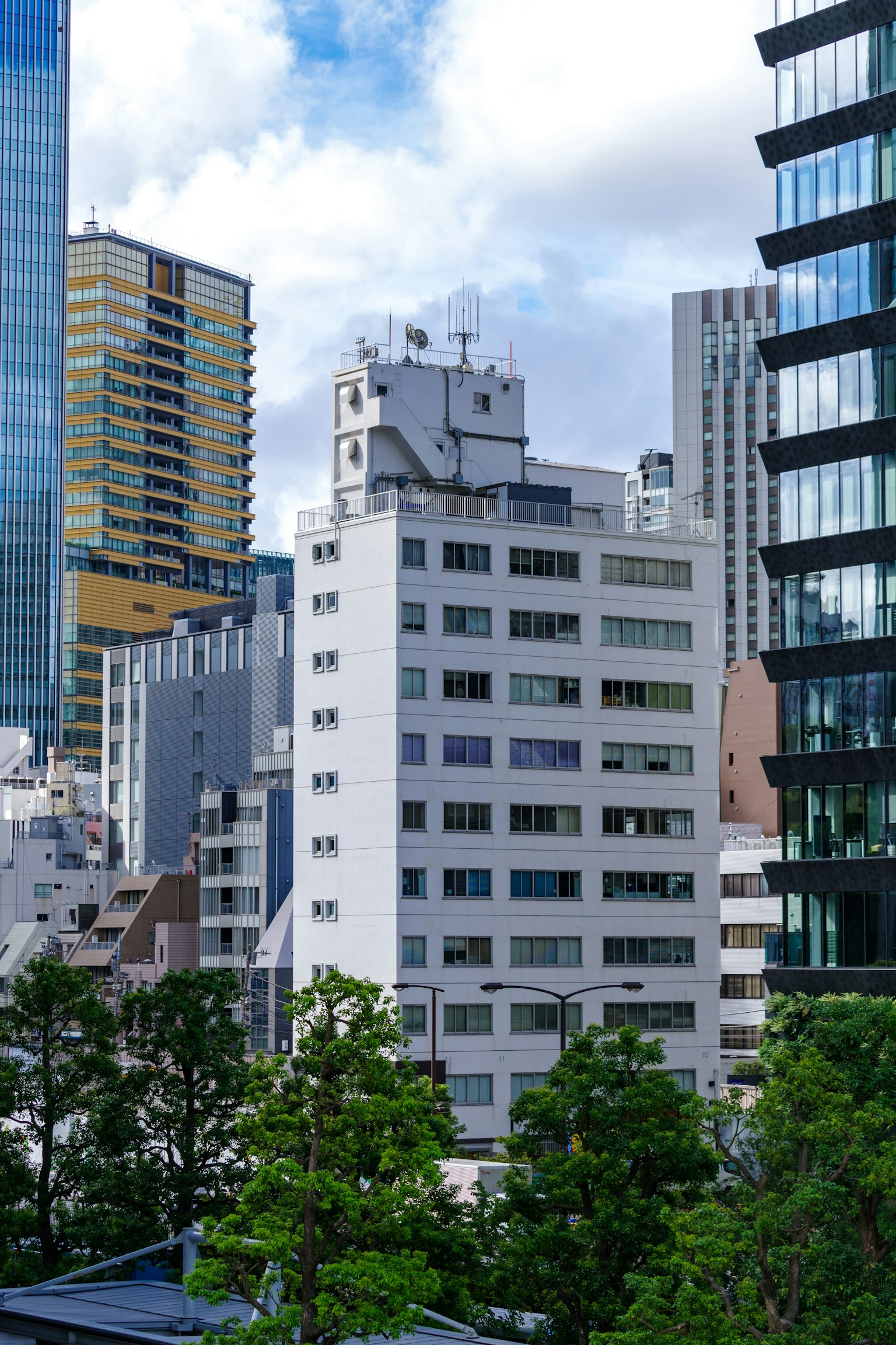 Stadtbild von Tokio mit modernen Wolkenkratzern und grünen Bäumen