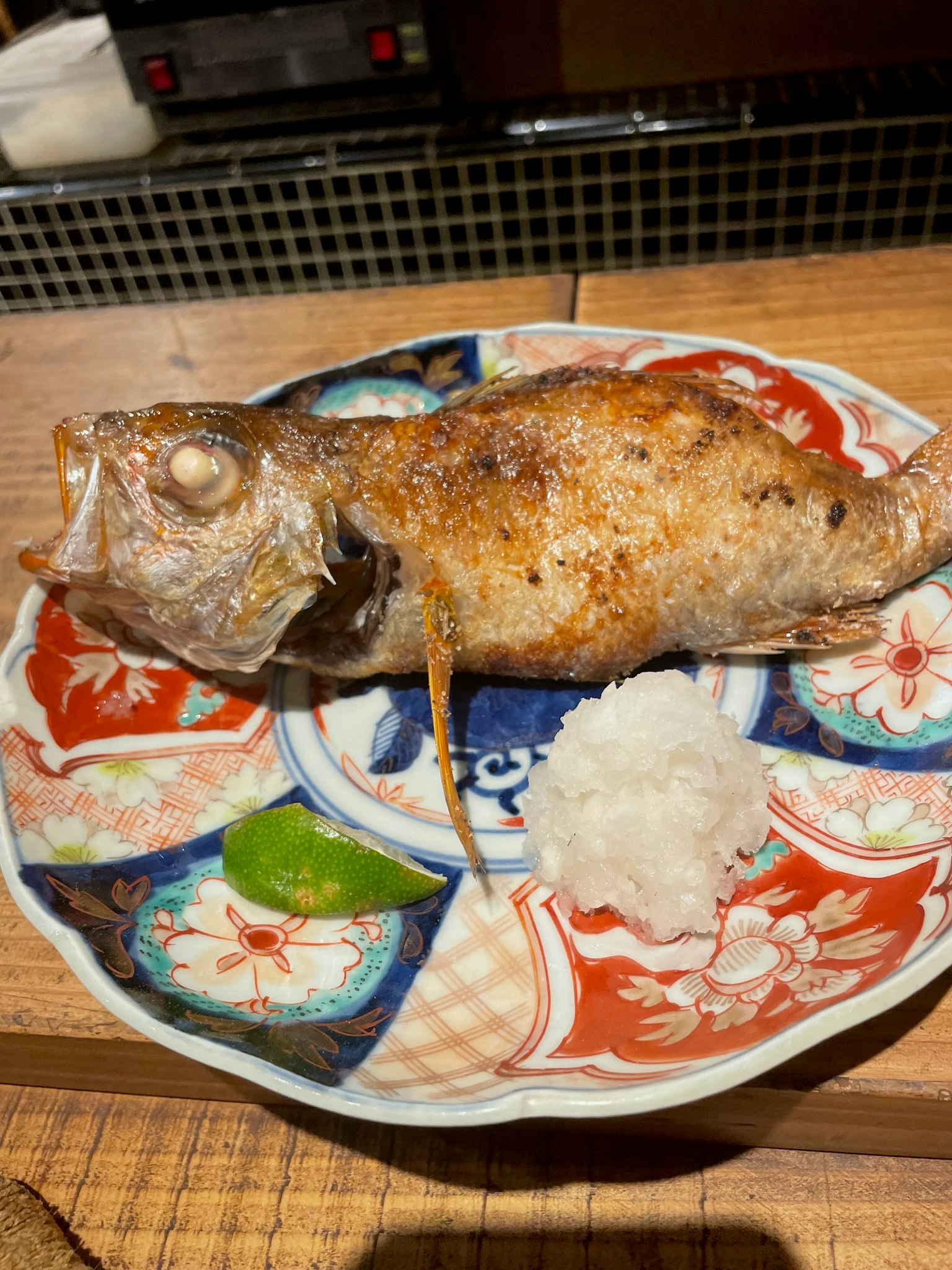 Grilled fish served with grated daikon on a decorative plate