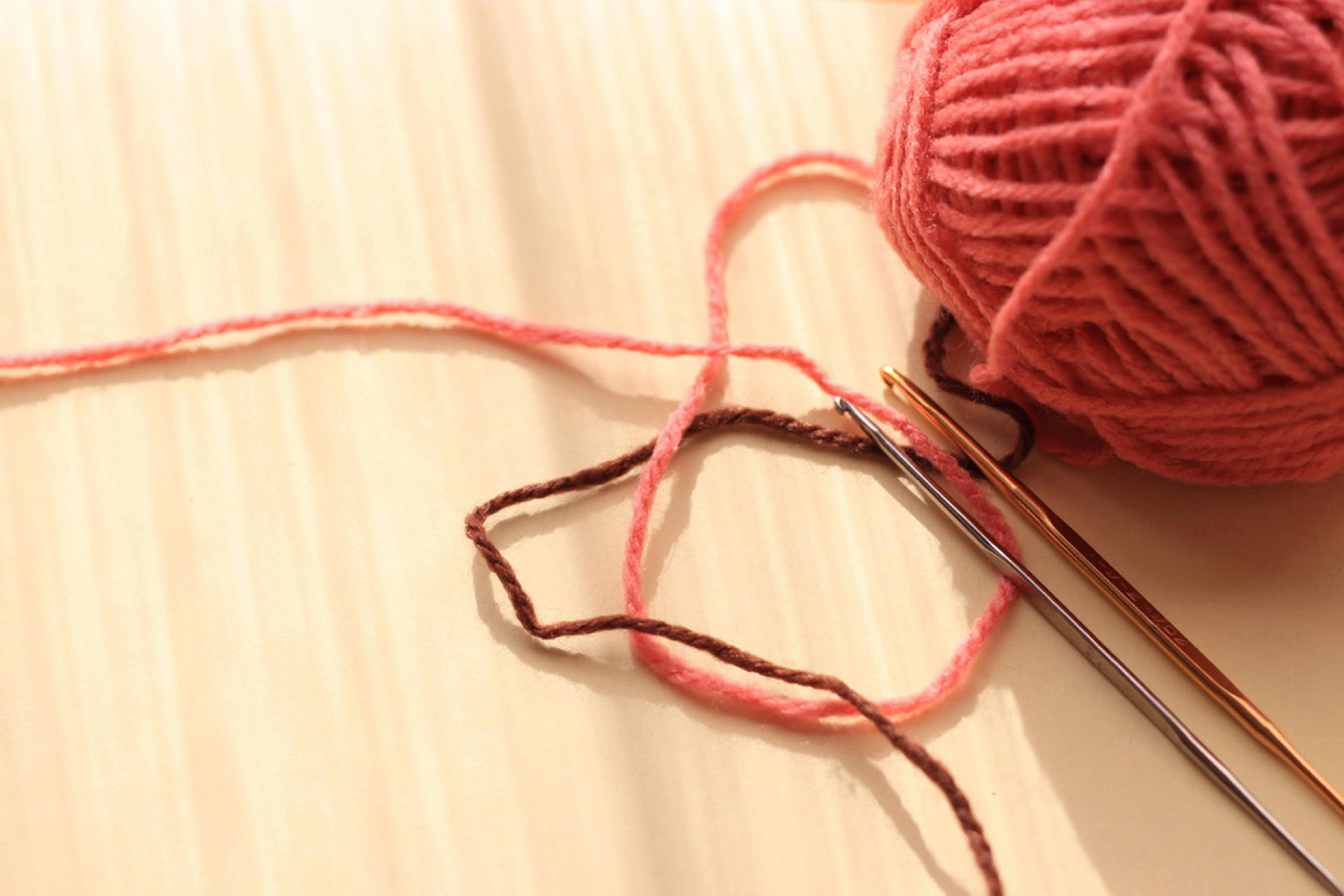red yarn ball and knitting needles craft work scene
