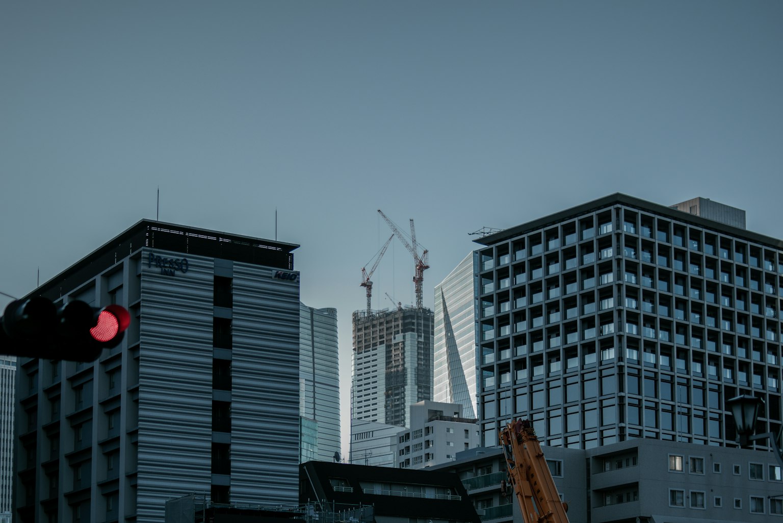 黃昏時分的城市景觀，包含摩天大樓和建築工地
