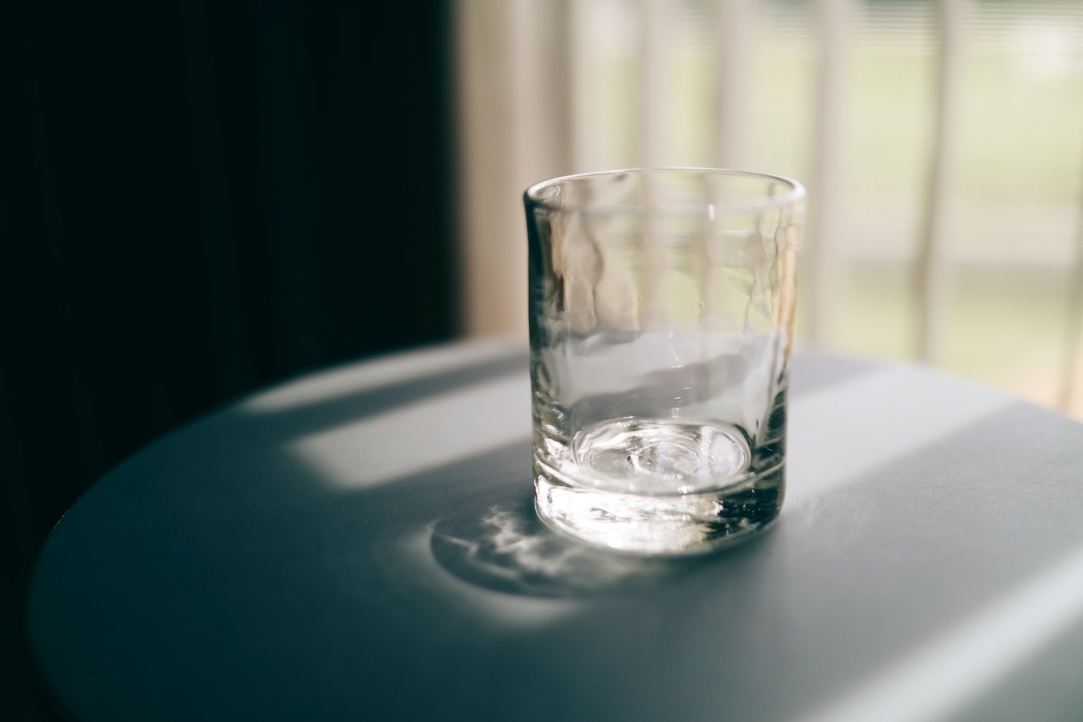 桌子上的透明玻璃杯,阳光投射出阴影