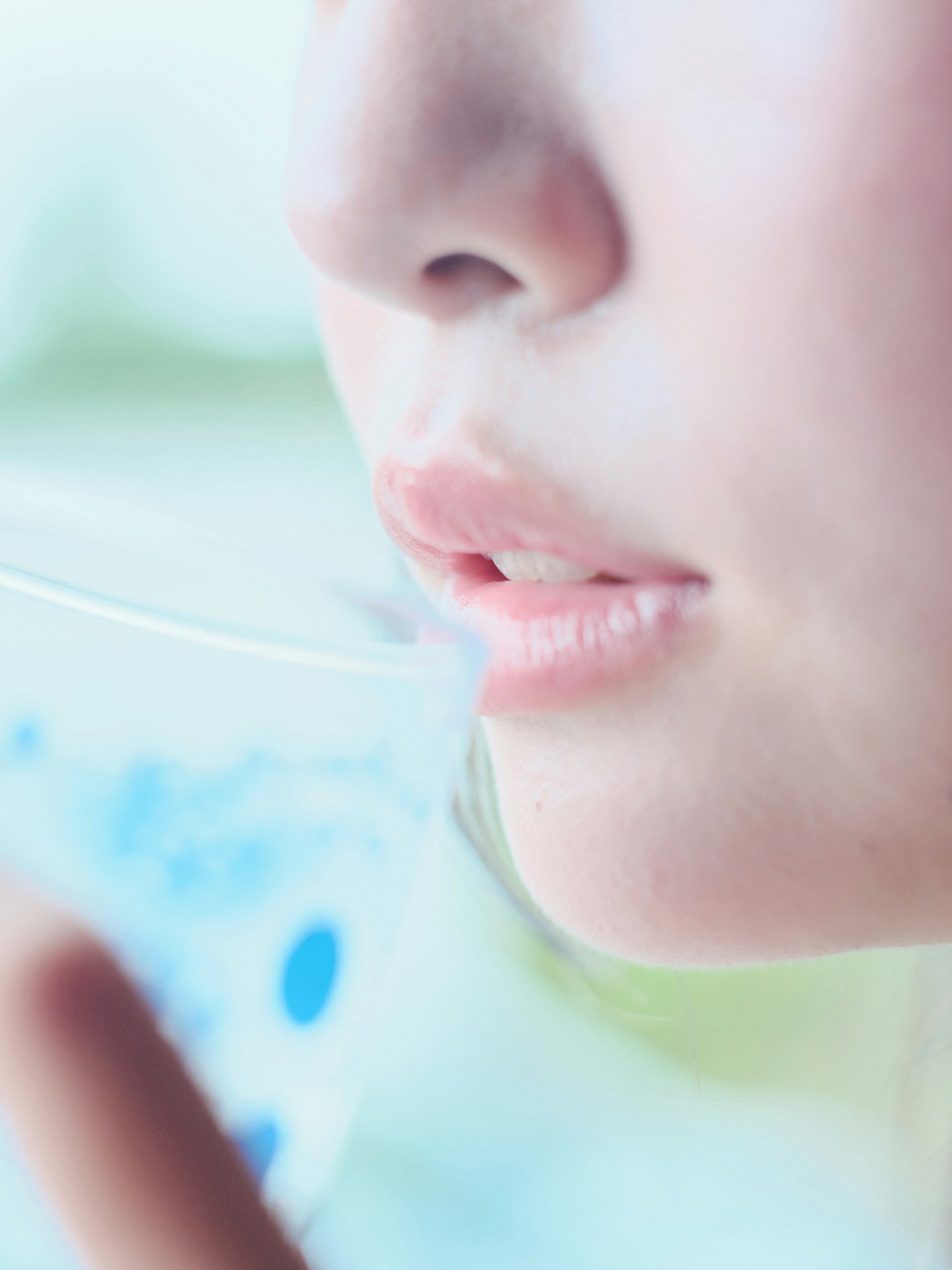 女性が透明なグラスから水を飲もうとしている様子のクローズアップ