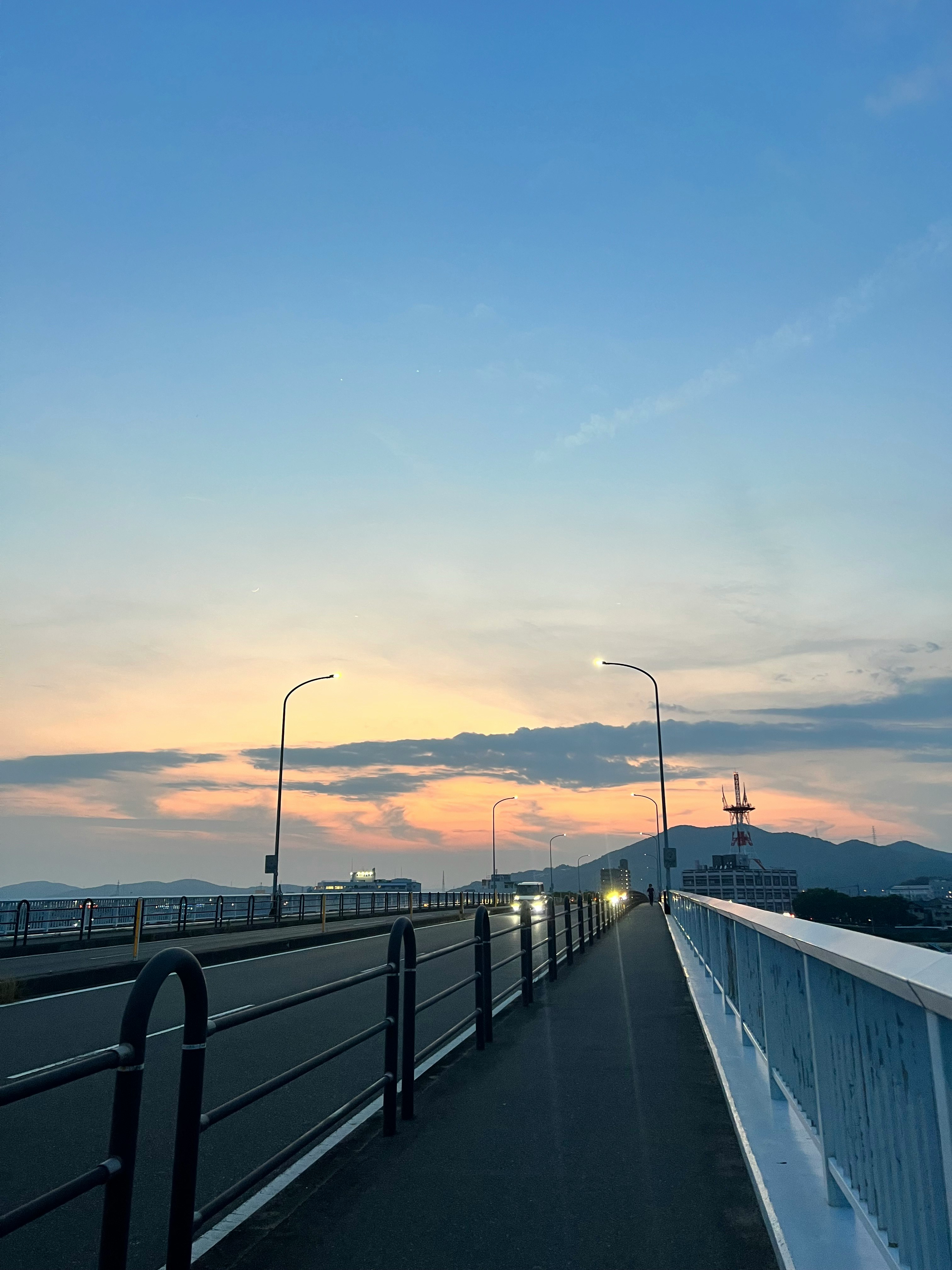 夕暮れの歩道と海沿いの橋の眺めのグラデーション