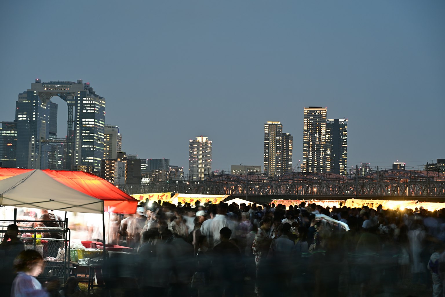 夜景の都市と大勢の人々がいる屋外イベントの様子