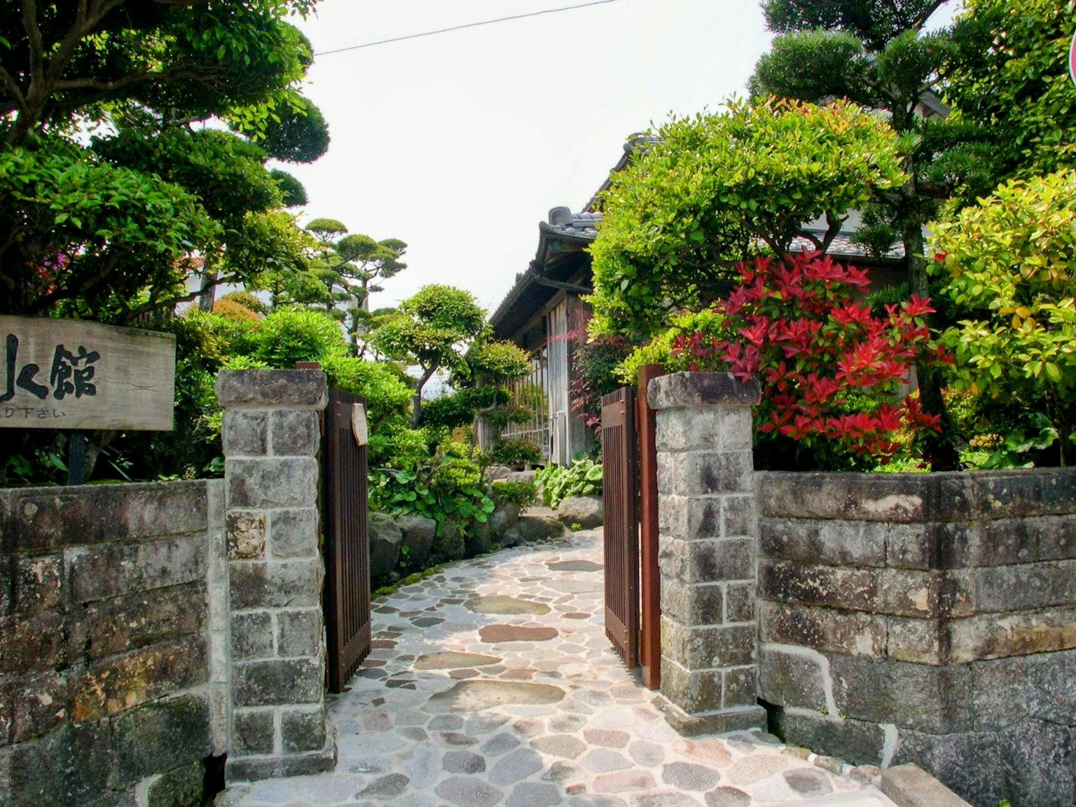 传统日本住宅的入口，拥有美丽的花园，特色是石墙和木门