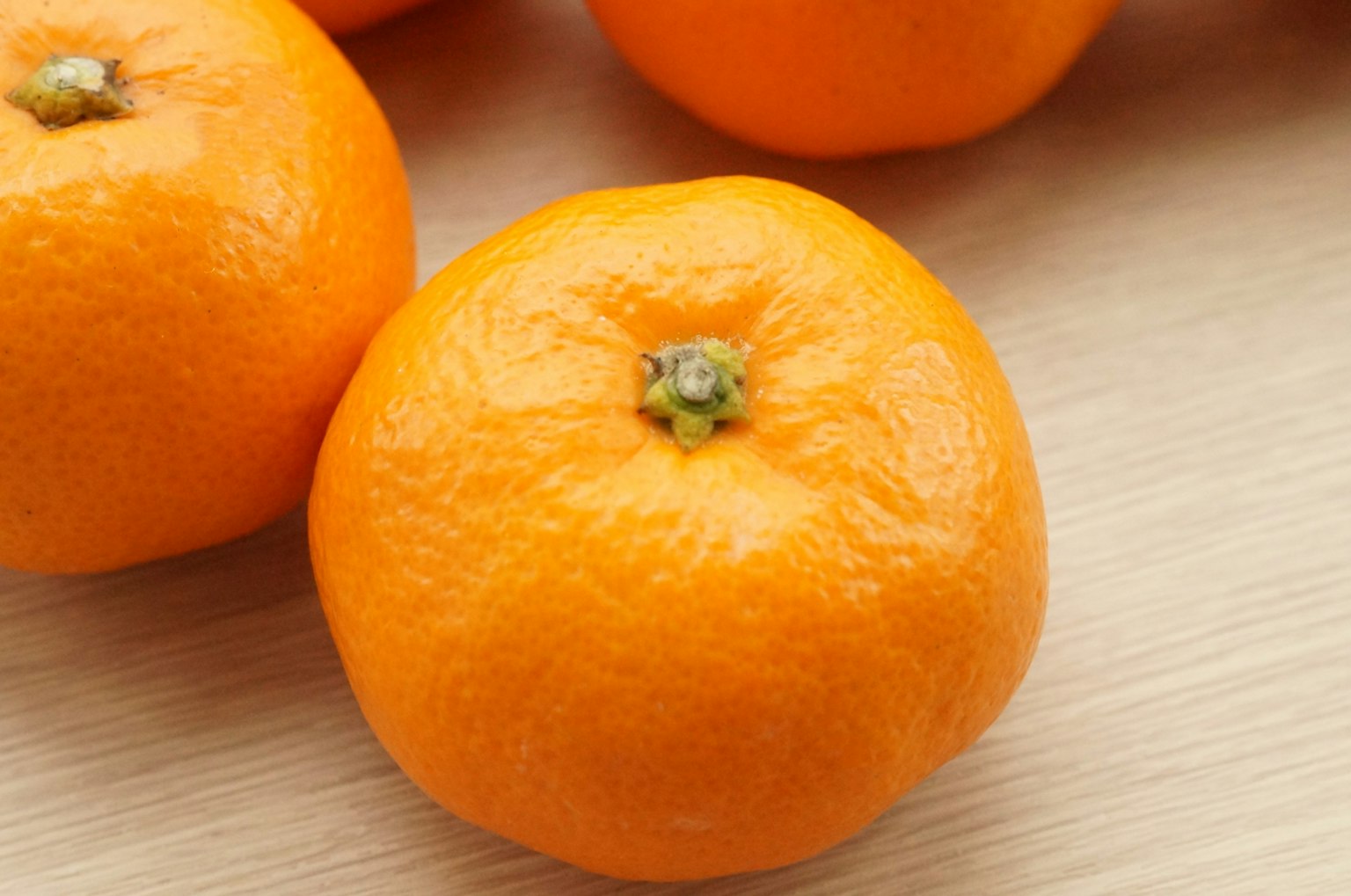 Jeruk mandarin oranye cerah diletakkan di atas meja kayu