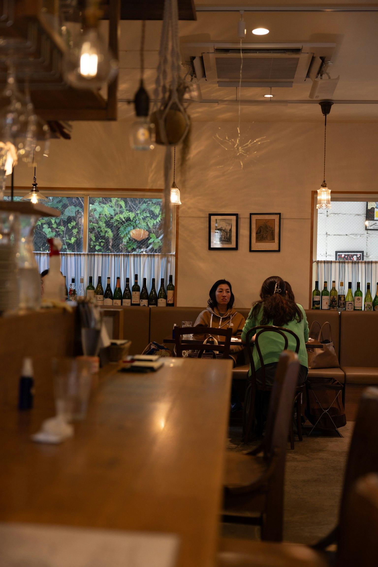 Interior of a casual restaurant with wooden counter and seating where customers are enjoying their meals