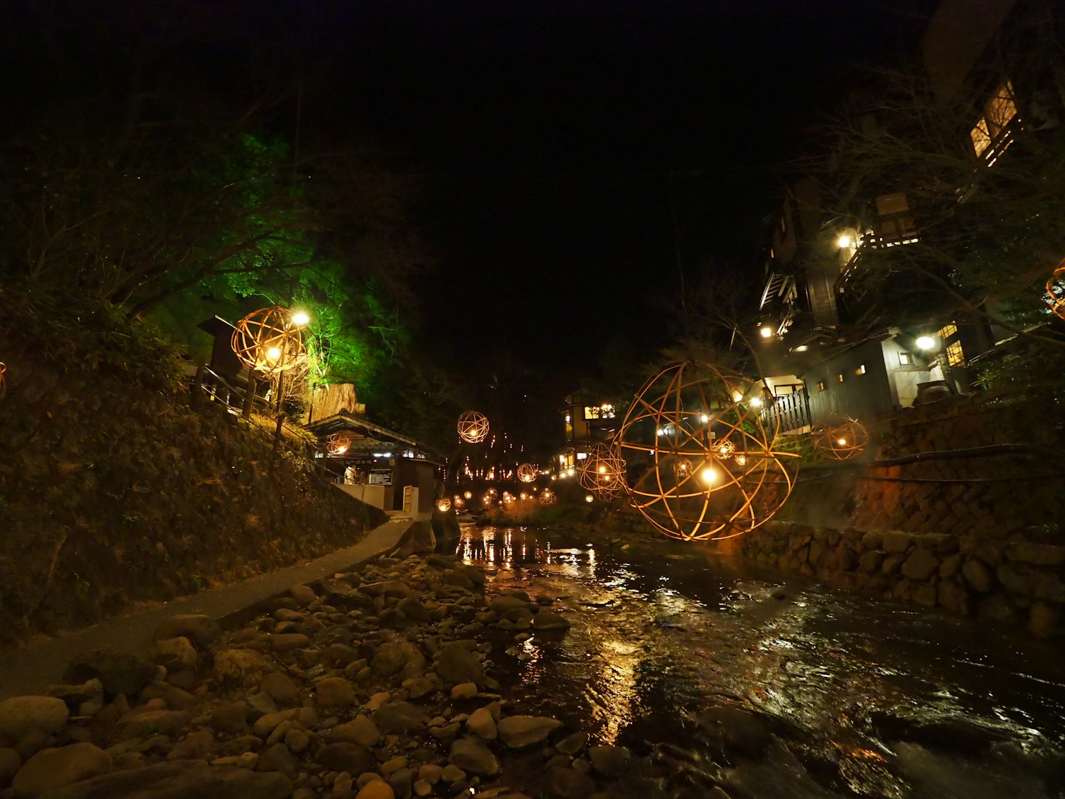 夜晚的河流美景，溫暖的燈光和裝飾性球體結構照亮