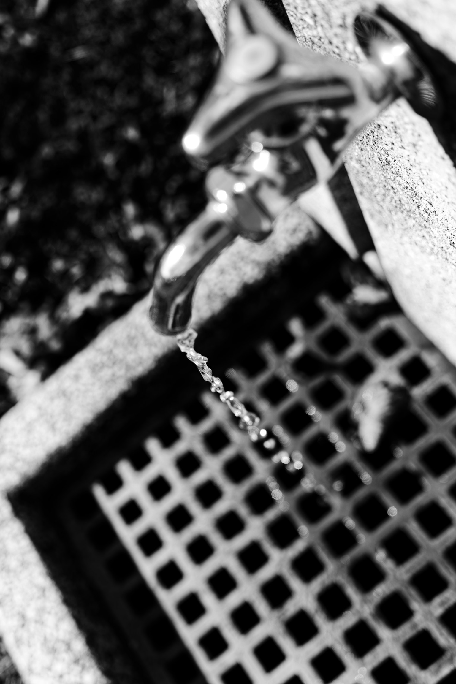 Immagine in bianco e nero di un rubinetto che gocciola acqua