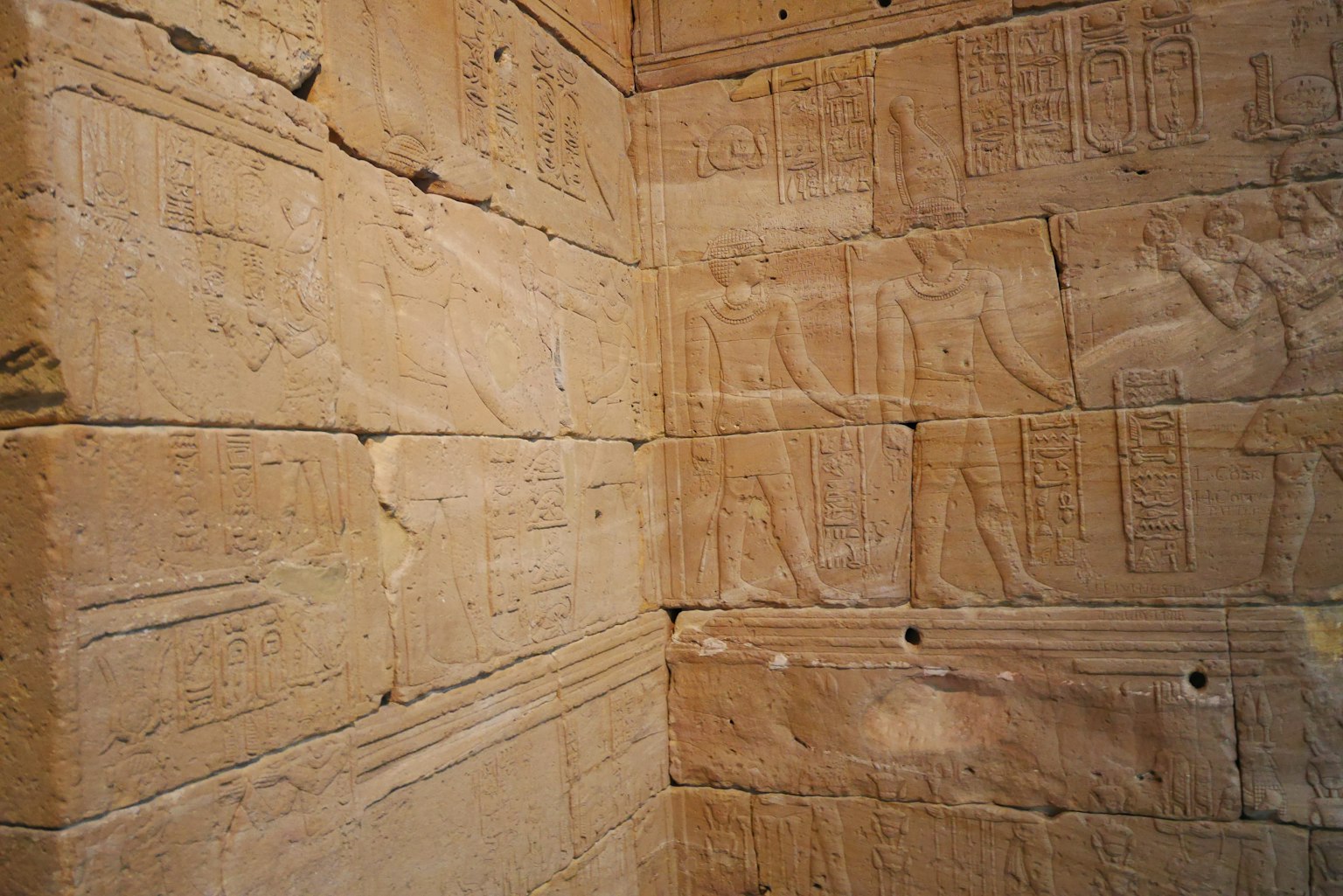 Corner of a stone wall featuring ancient Egyptian hieroglyphs