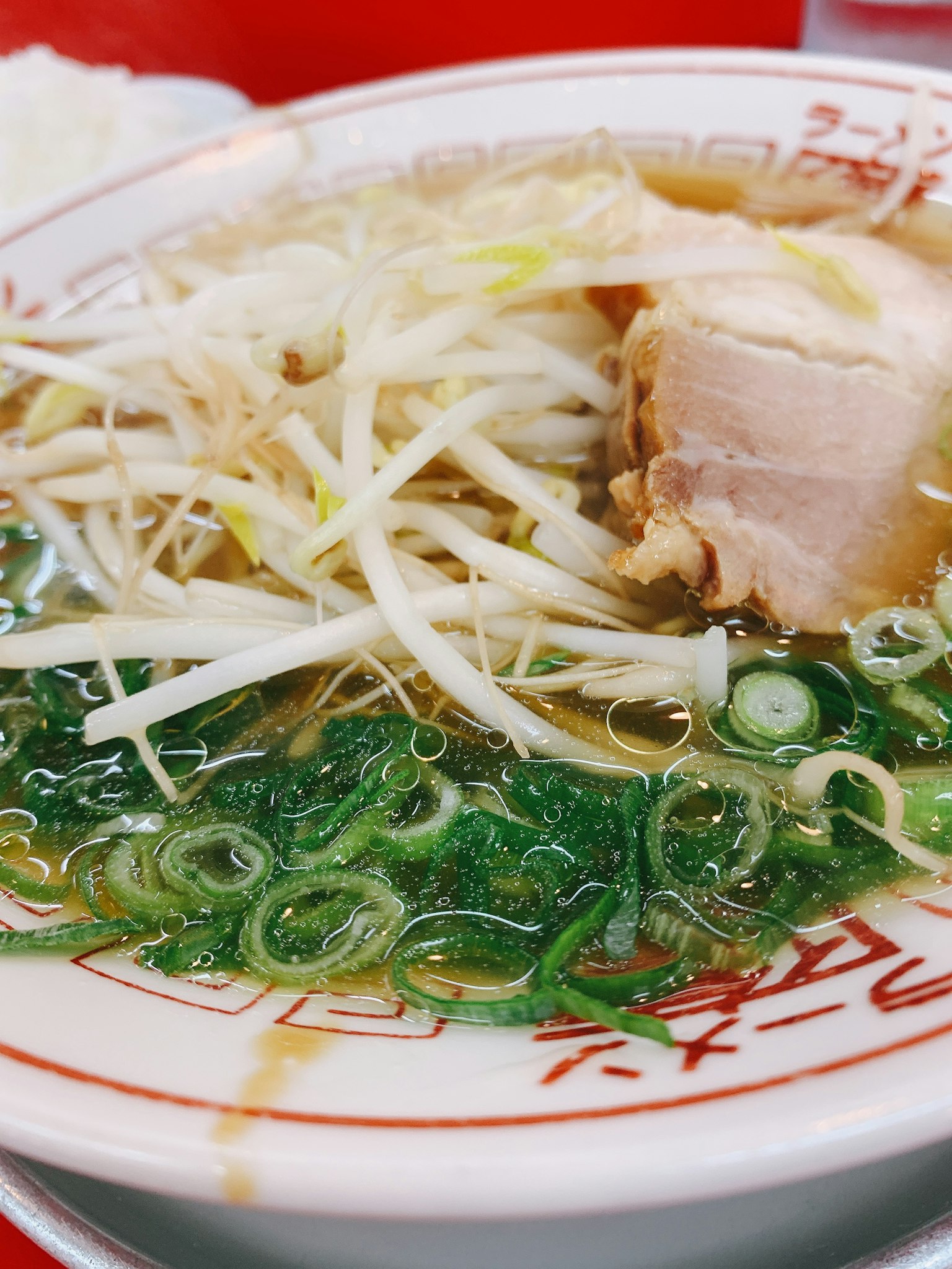 Bowl of ramen topped with sliced pork and green onions
