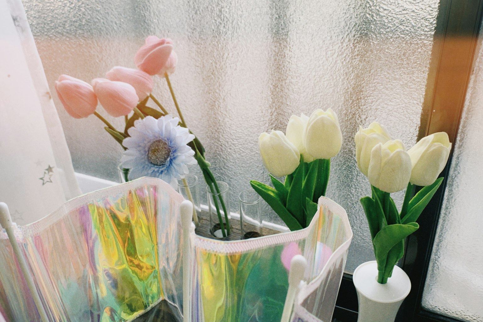 Susunan bunga pink dan tulip putih yang berwarna-warni dalam vas