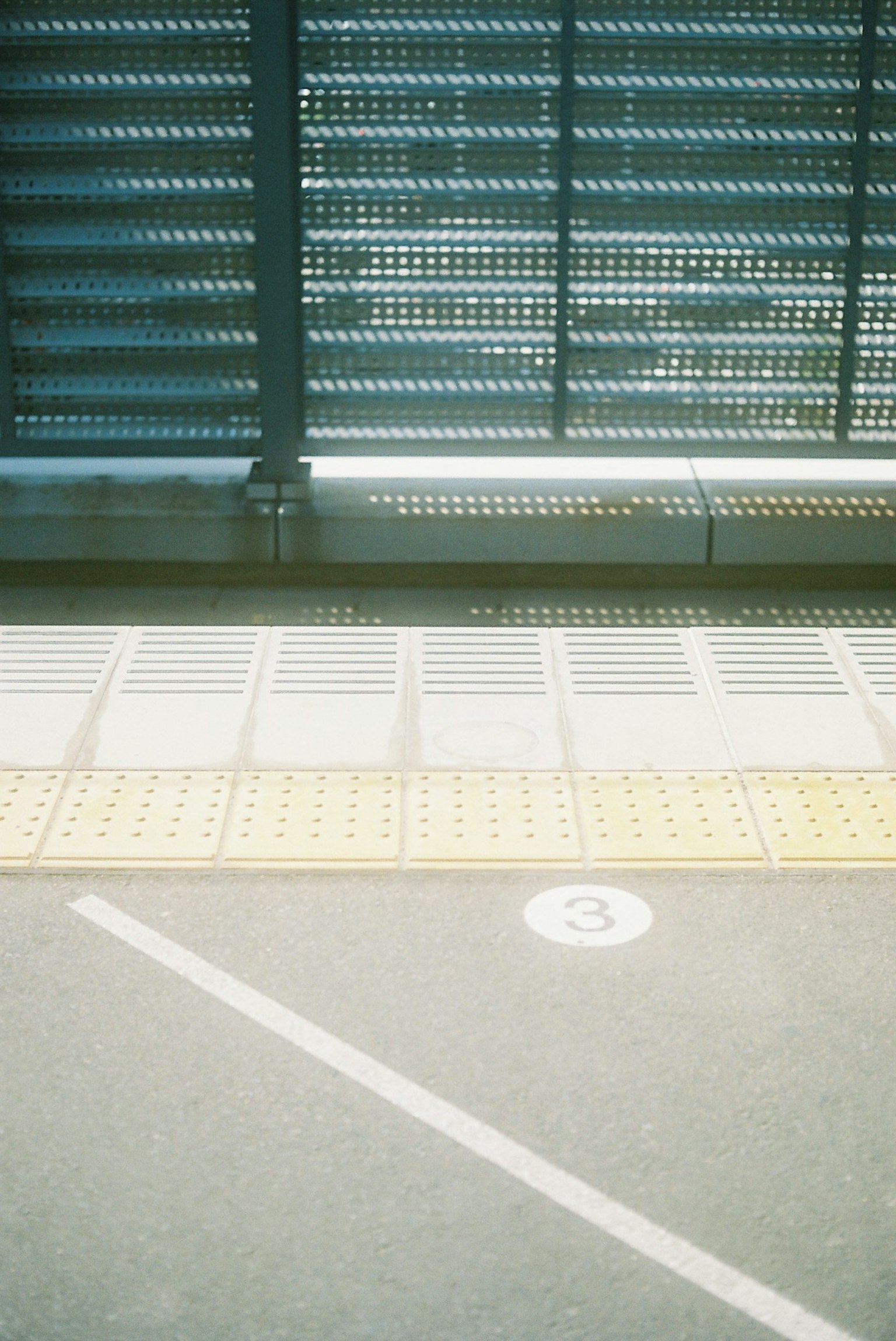 Bagian dari platform kereta dengan panel logam dan paving taktil