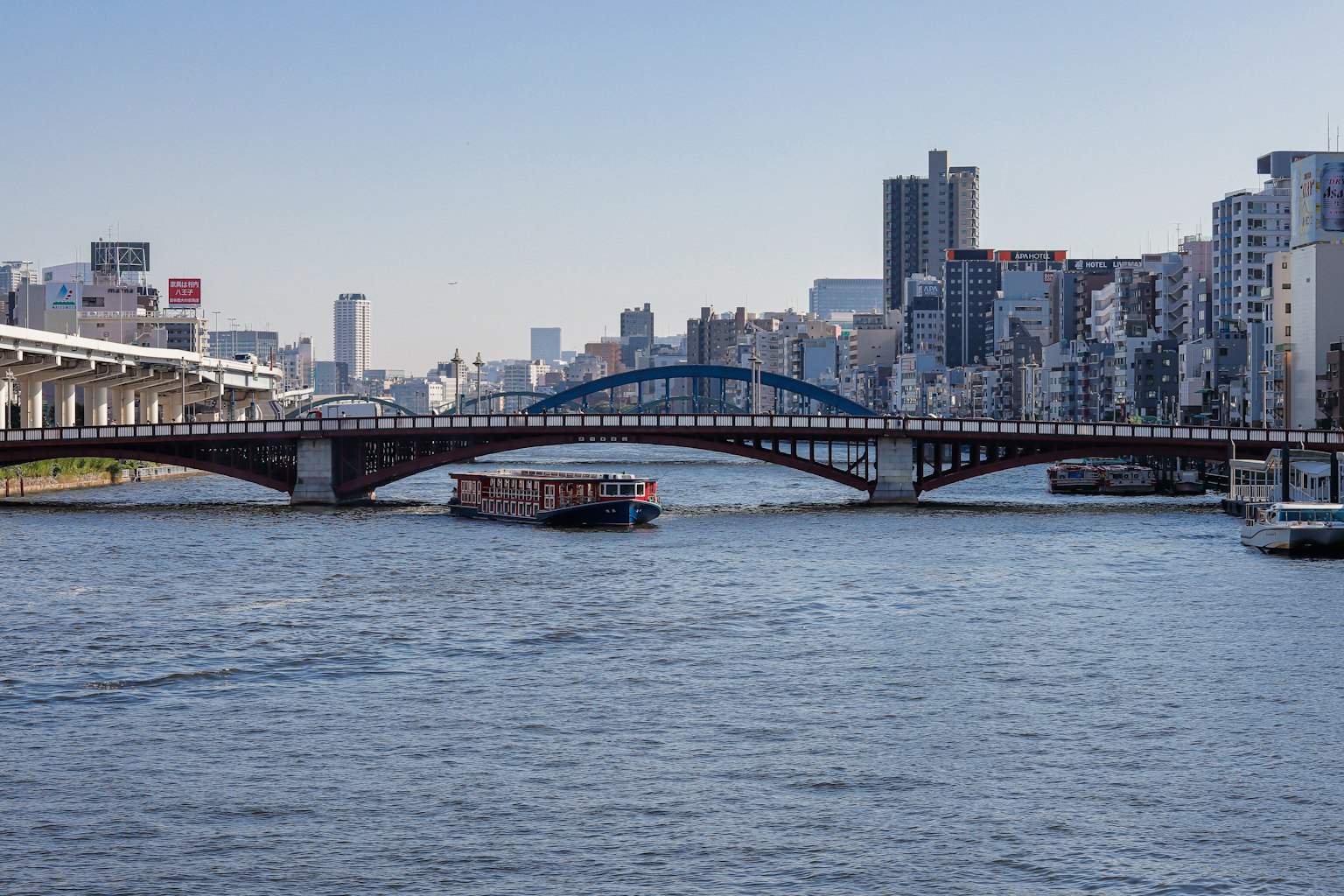 Paysage urbain avec un pont sur une rivière et des bateaux