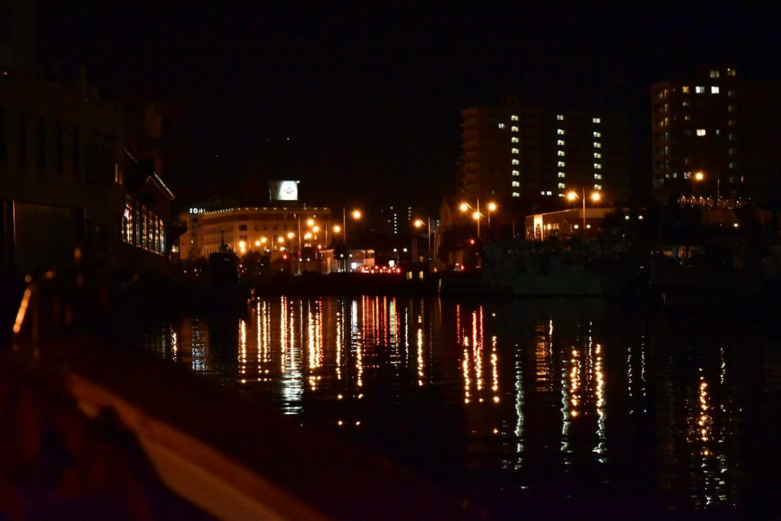 City lights and buildings reflected in a river at night
