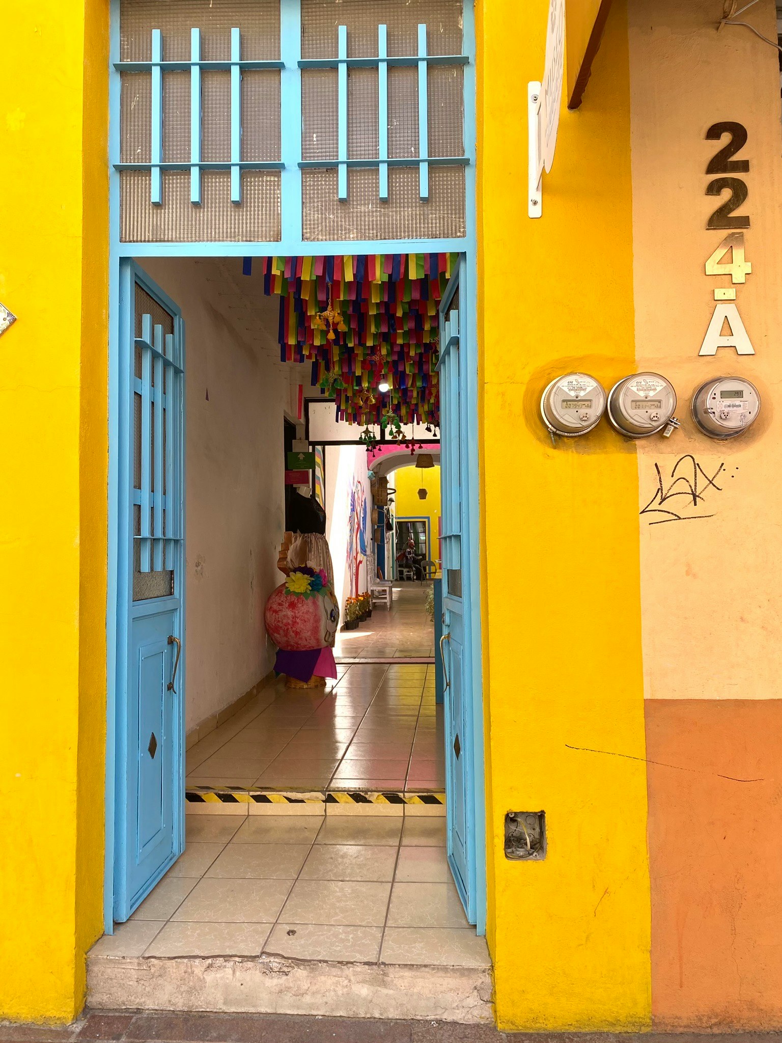 Gang masuk dengan pintu biru dan dinding kuning