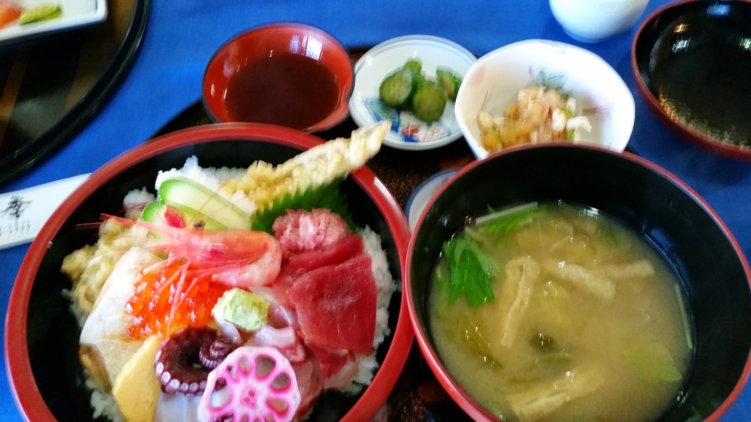 Bunt dekorierter Sashimi und Tempura in einer Schüssel mit einer Schale Misosuppe