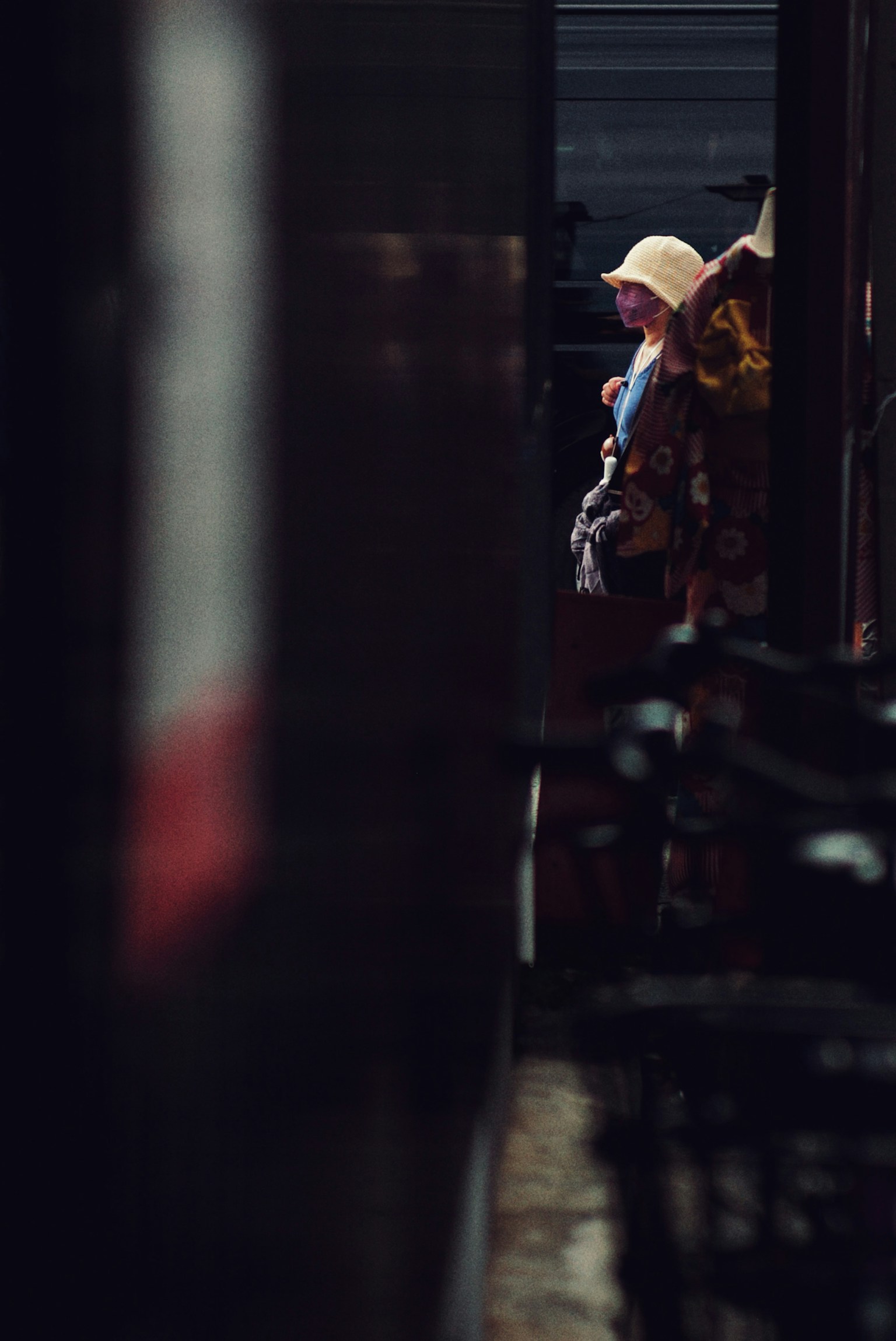 Một người đội mũ đứng trong hành lang tối