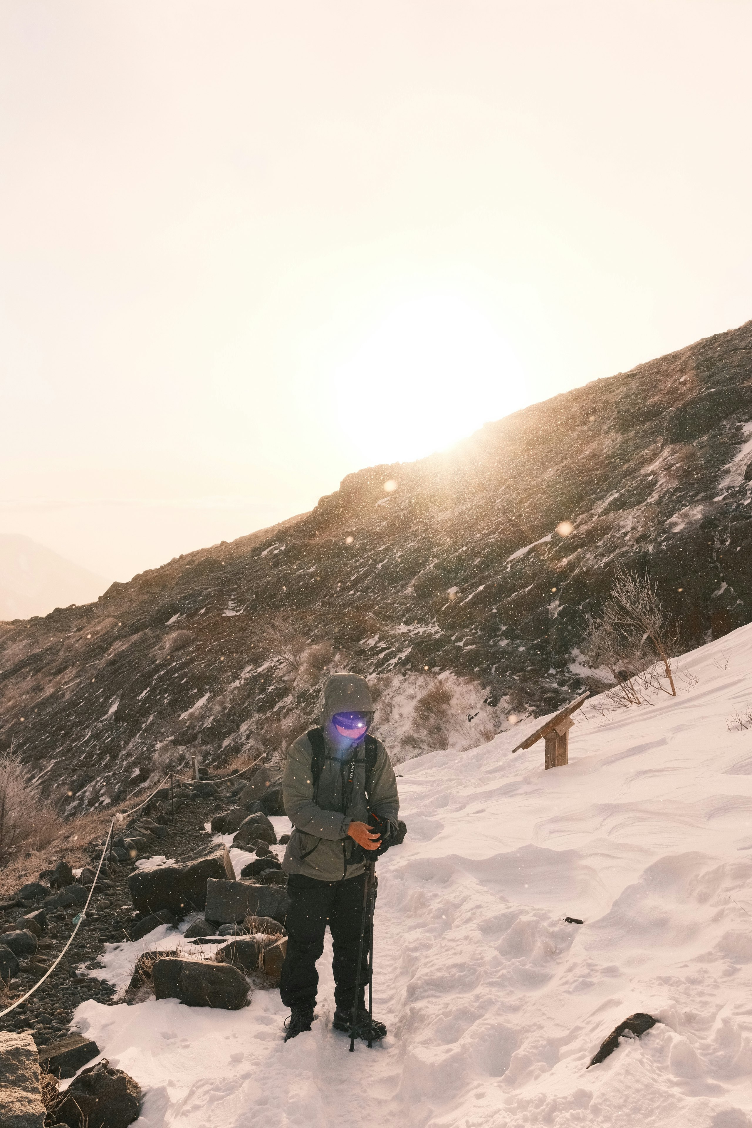 雪の稜線で立つ登山者と朝日の山並み