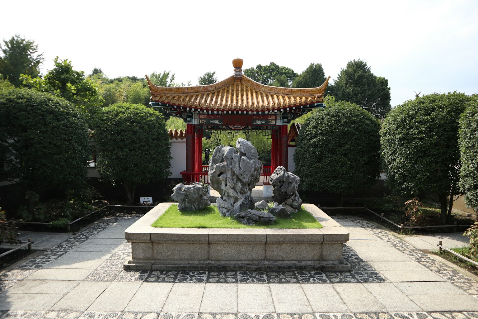 花园中央的石雕和传统中国屋顶的凉亭