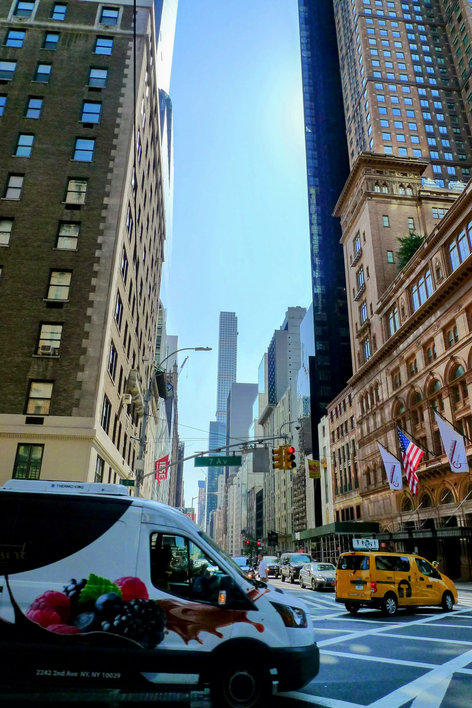 Intersección con un taxi y una furgoneta de reparto frente al horizonte de Nueva York