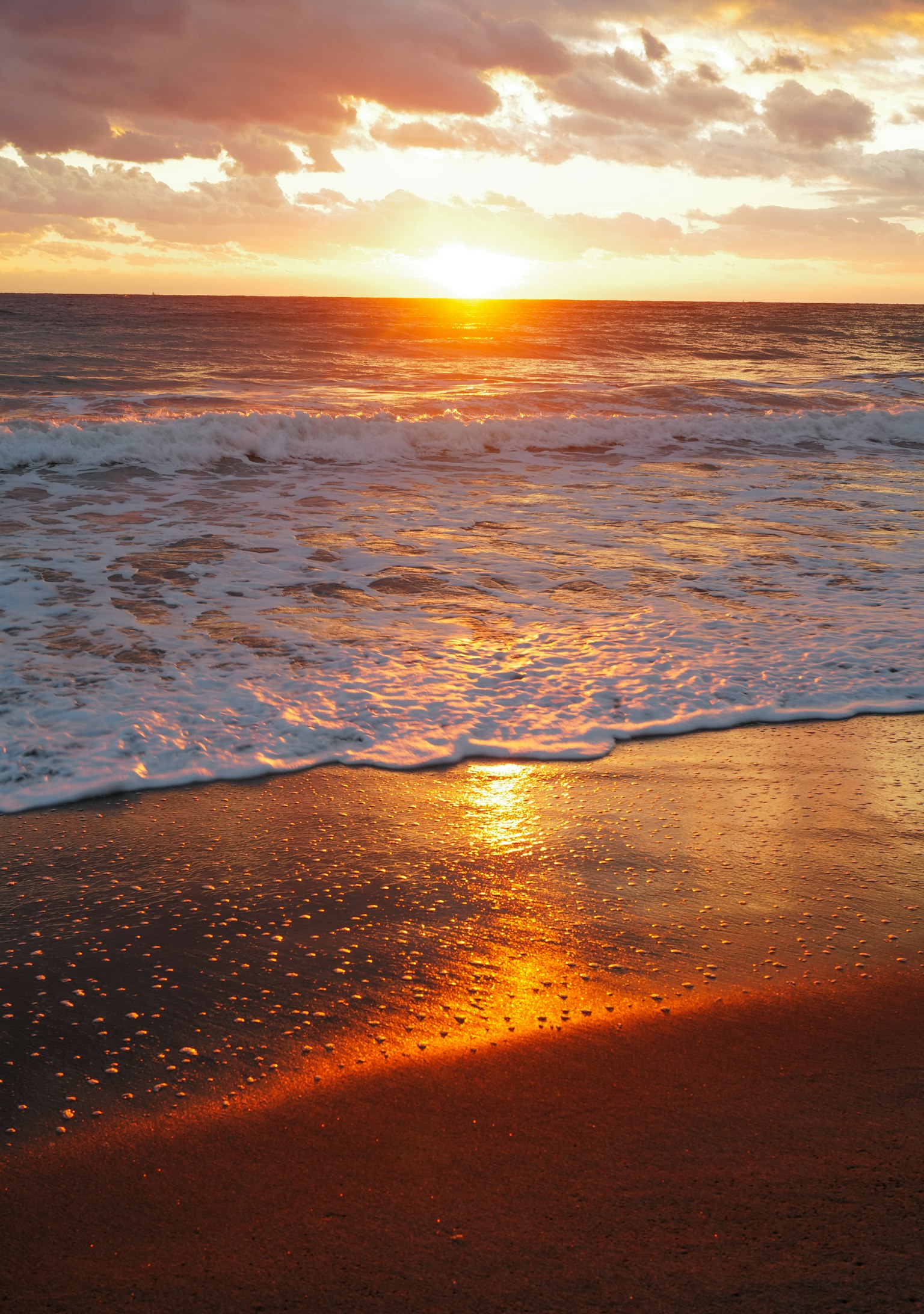 海滩场景，夕阳映照在海浪上