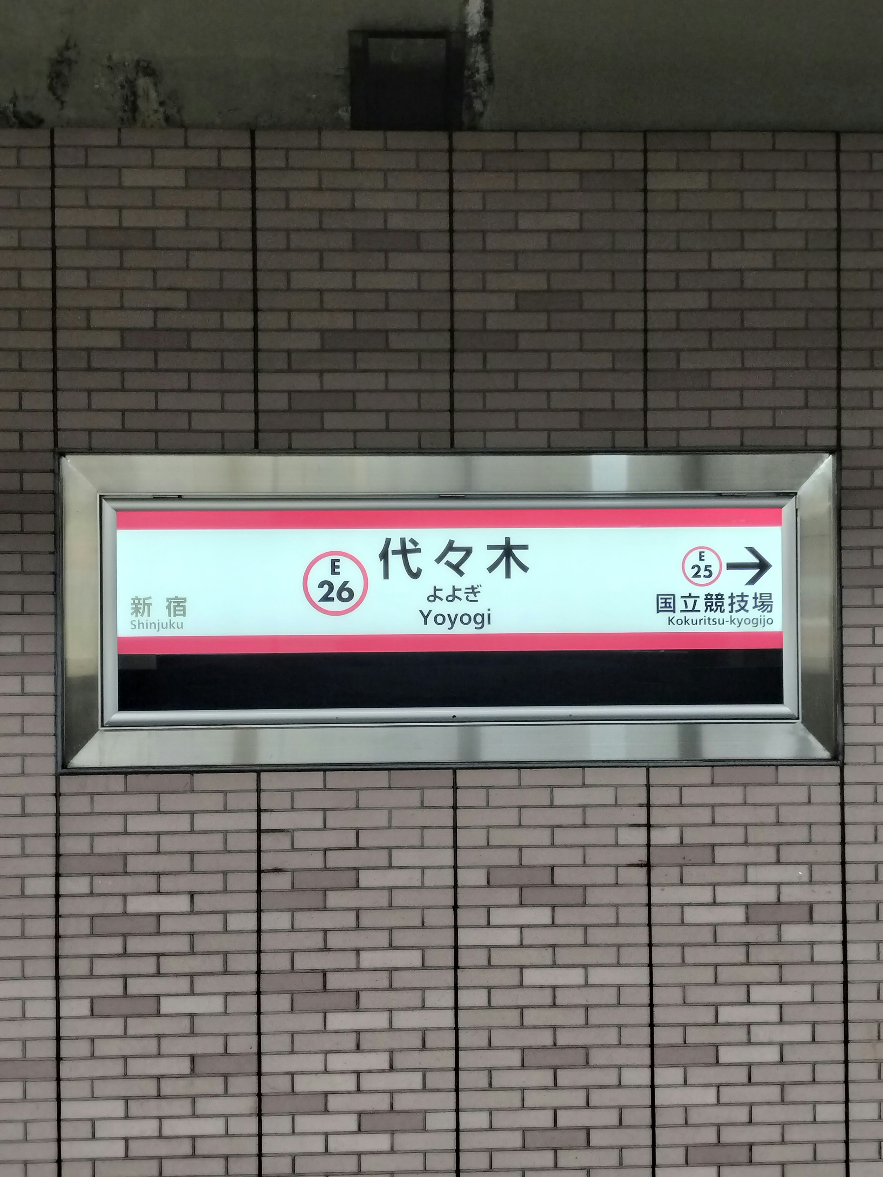 벽돌 벽에 걸린 역 목적 안내판