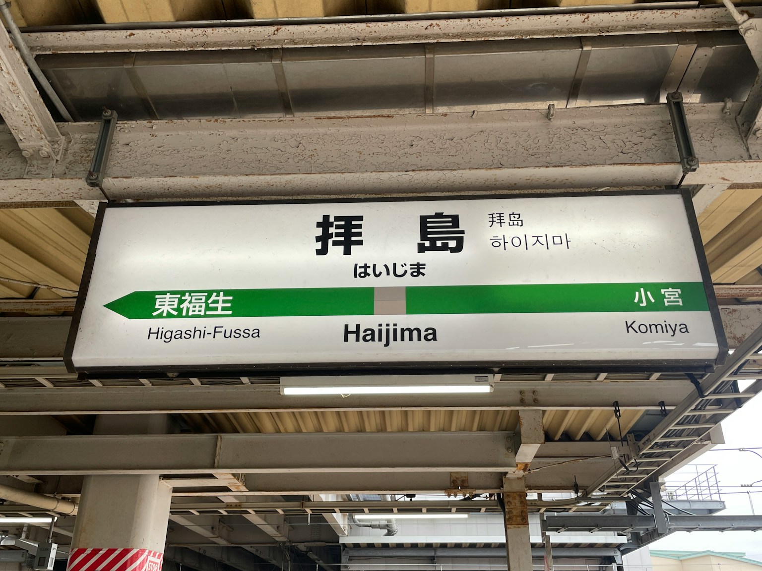 Schild der Haijima Station mit dem Stationsnamen in Japanisch und Englisch