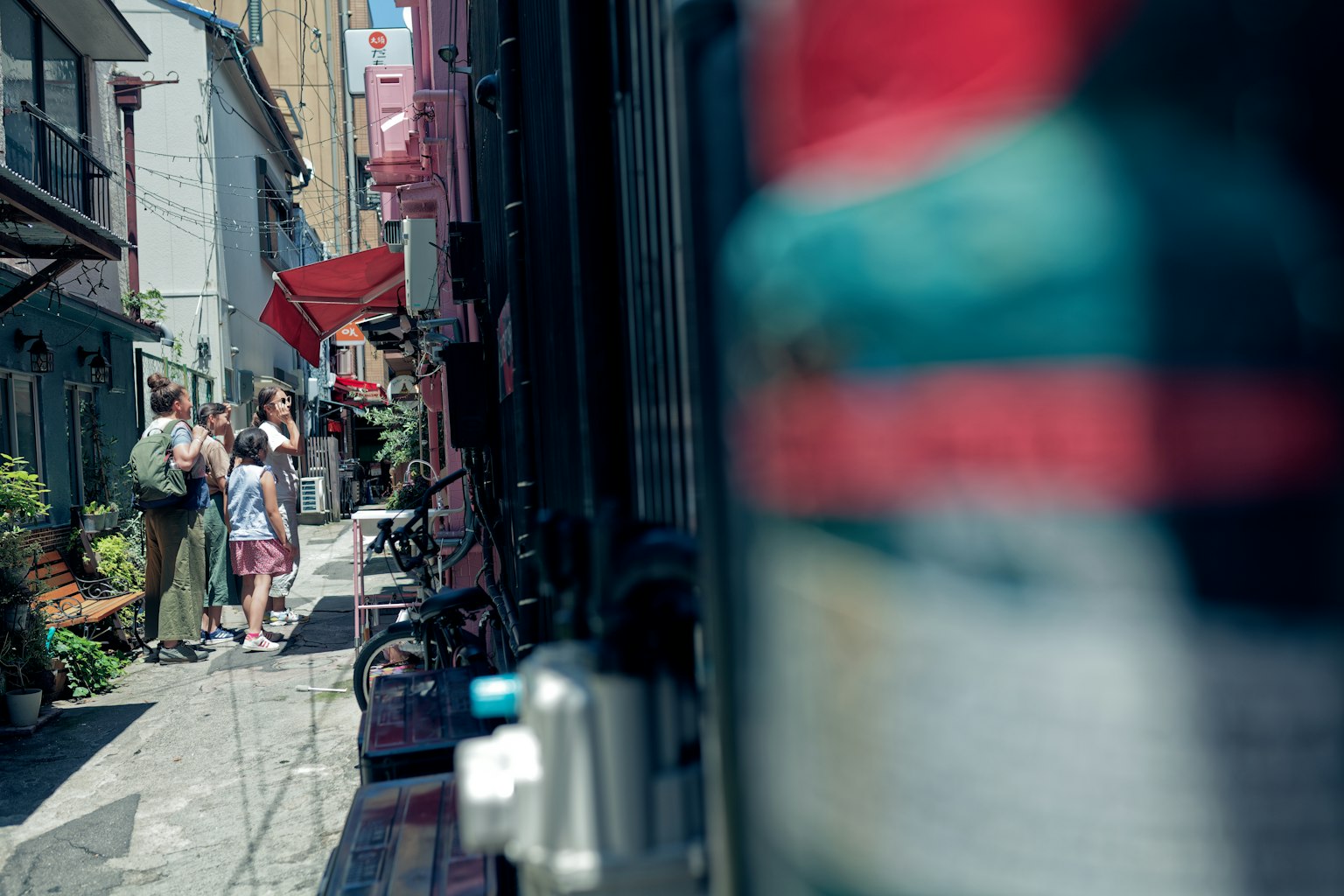 Persone in piedi in un vicolo stretto con insegne colorate