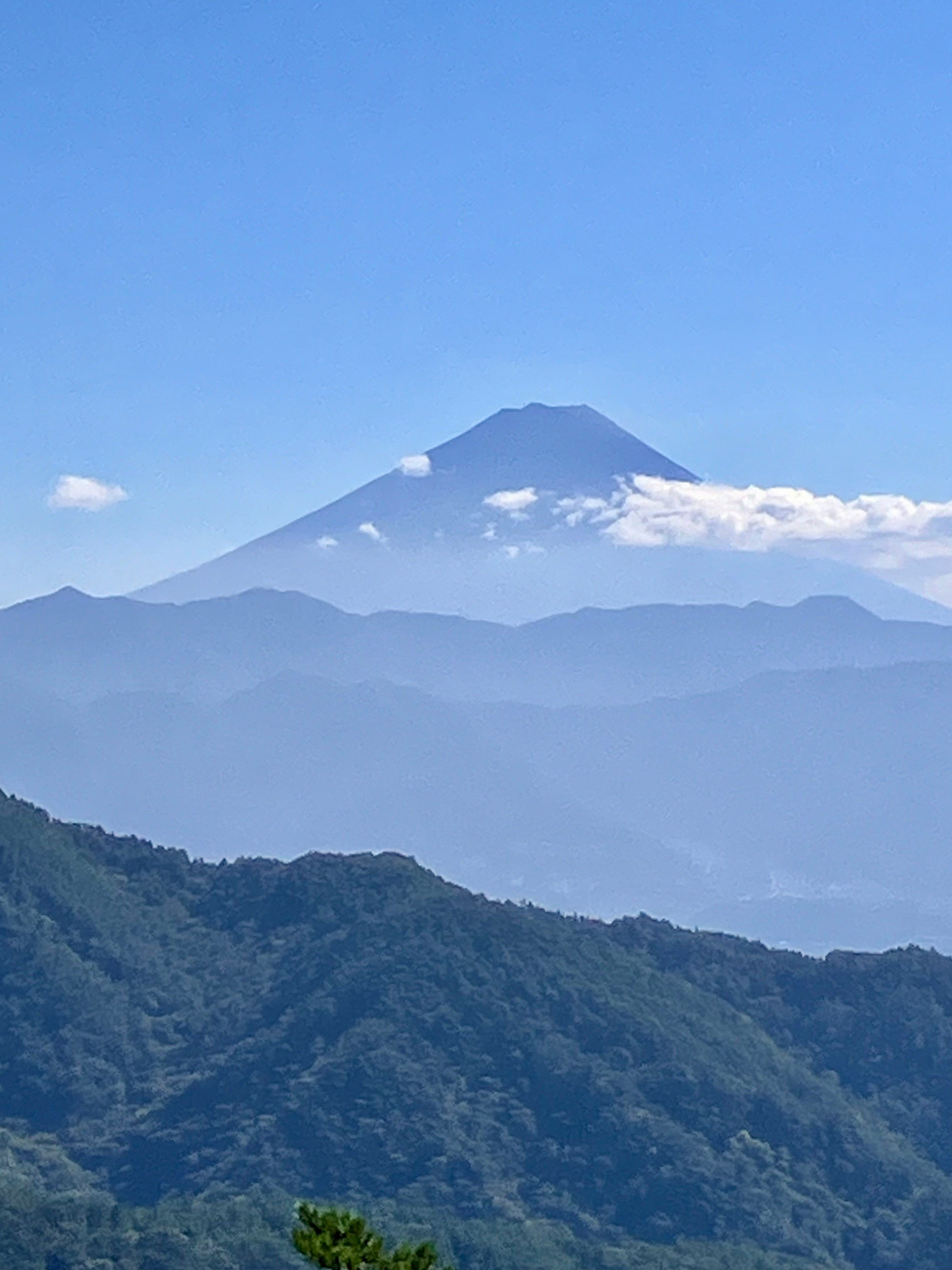雲のかかる富士山を望む山並みの景色