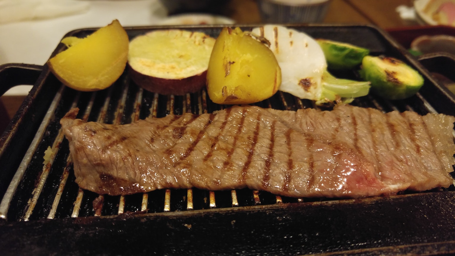 Grilled steak with assorted vegetables on a hot plate