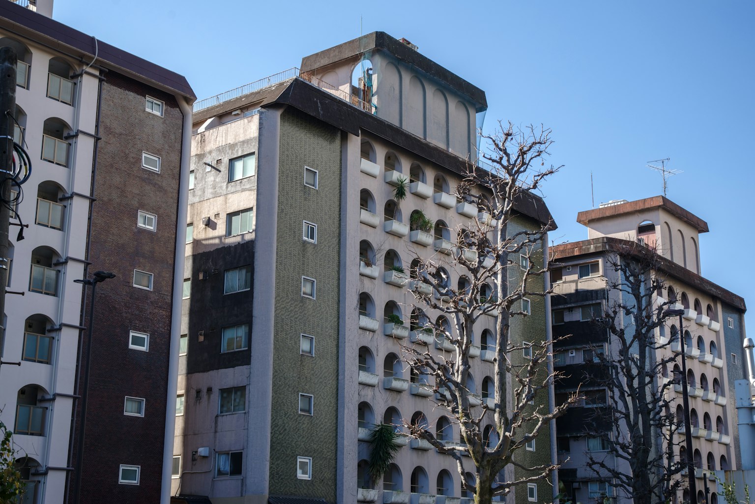 Riga di edifici con stili architettonici variati sotto un cielo blu chiaro