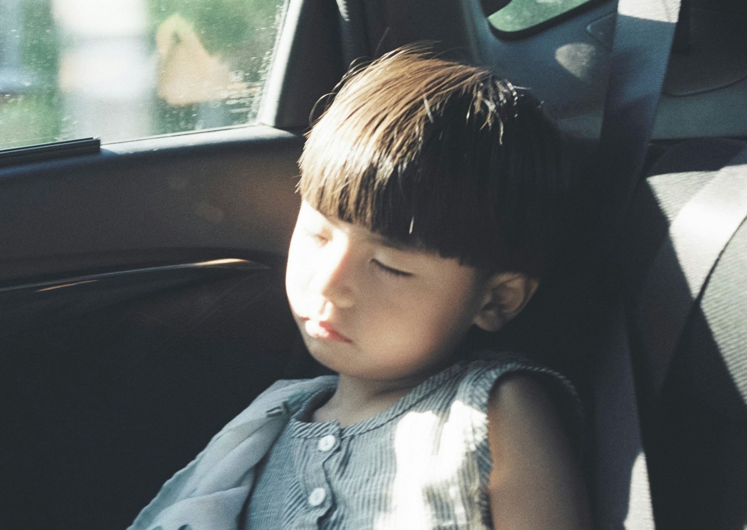 Bambino che dorme in auto Espressione serena Luce solare che entra