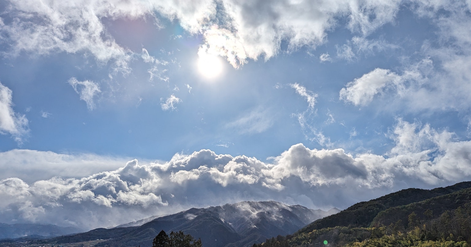 Schöne Landschaft mit Wolken und Sonne in einem blauen Himmel