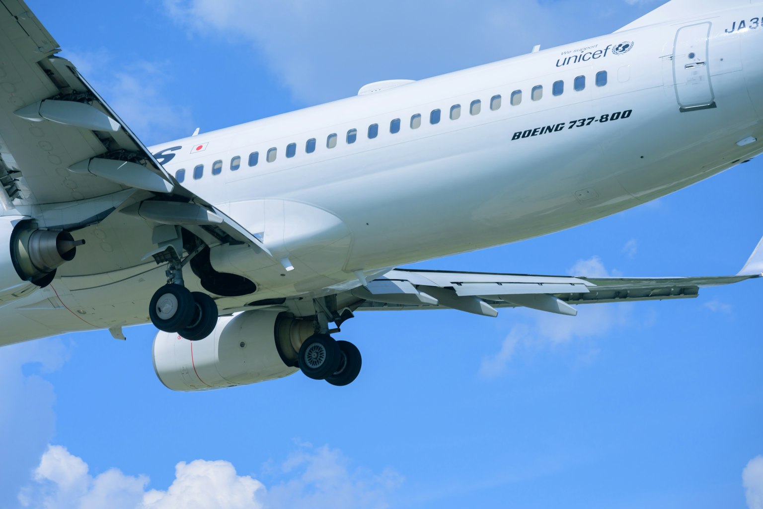 Aereo passeggeri bianco in volo contro un cielo blu