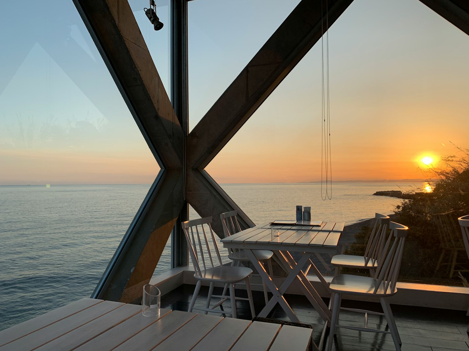 Vista del ristorante sul tramonto sull'oceano con tavoli