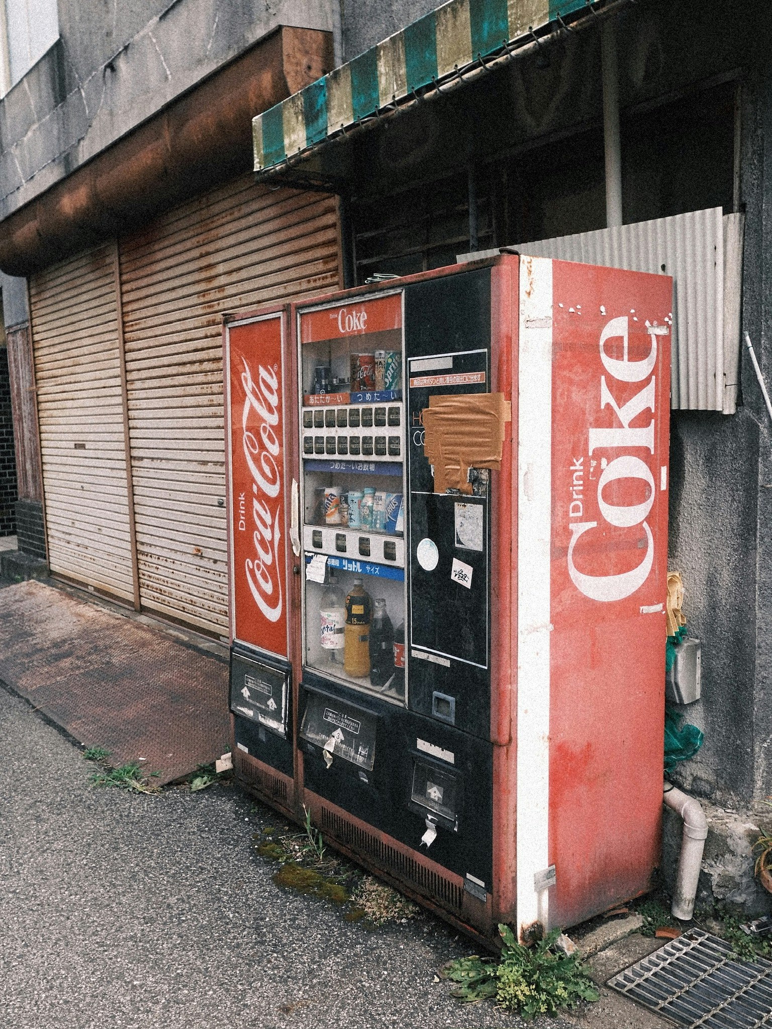 路地の壁沿いに並ぶ自動販売機