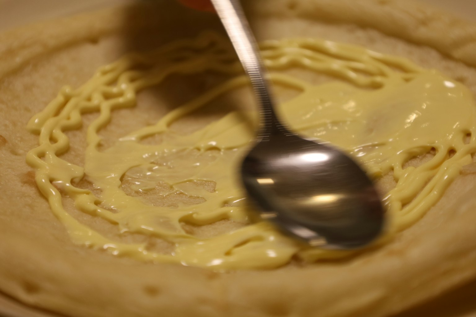 Mayonnaise auf einem Crêpe verteilen