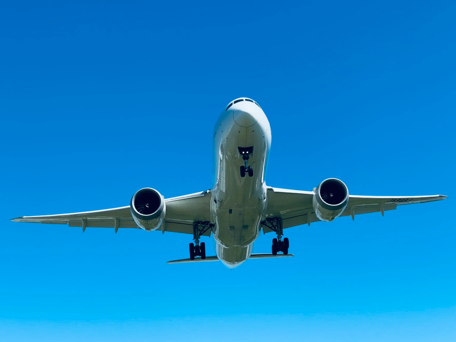 Passagierflugzeug fliegt gegen einen klaren blauen Himmel aus einem niedrigen Winkel