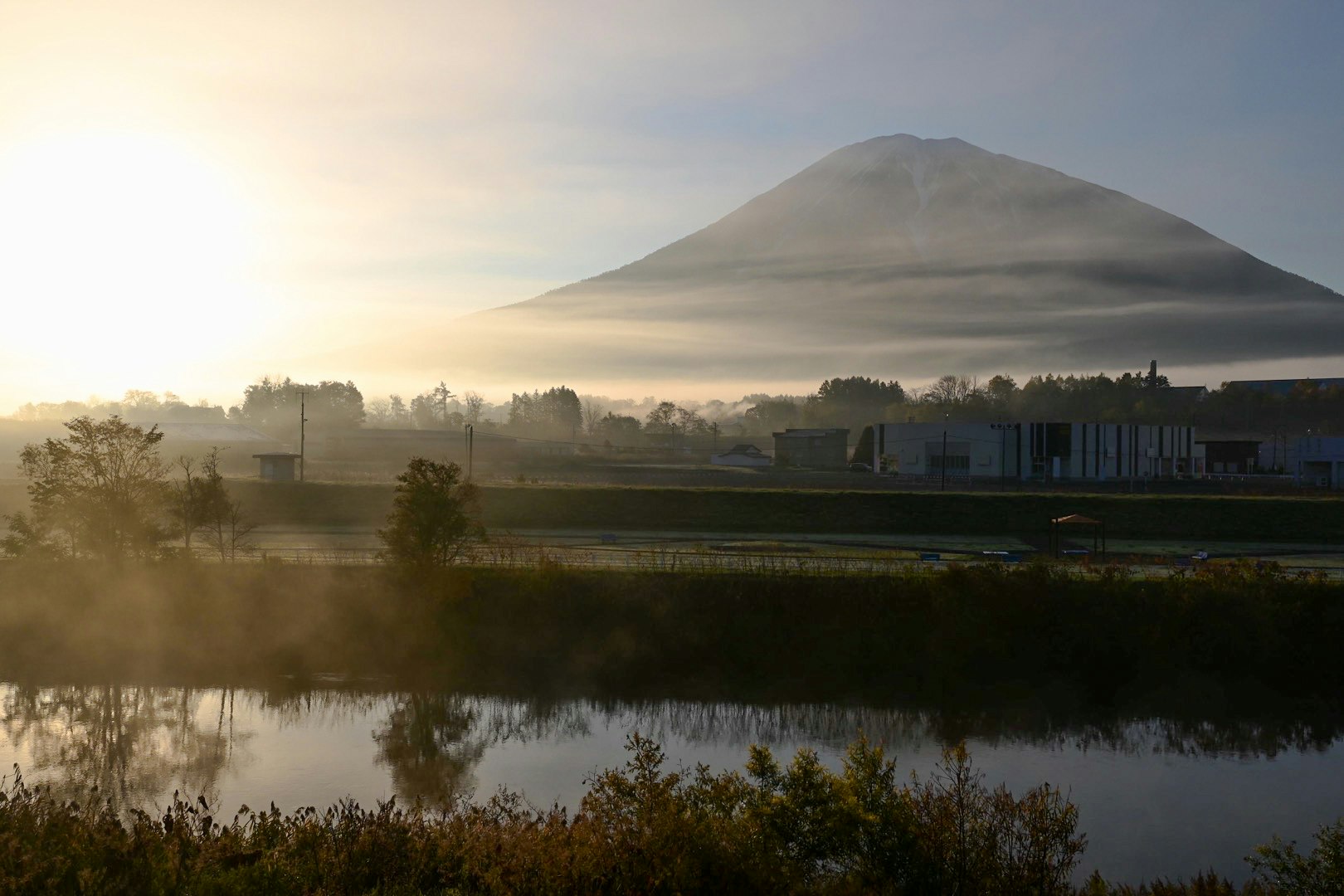 夕暮れの湖と遠くにそびえる山のシルエット