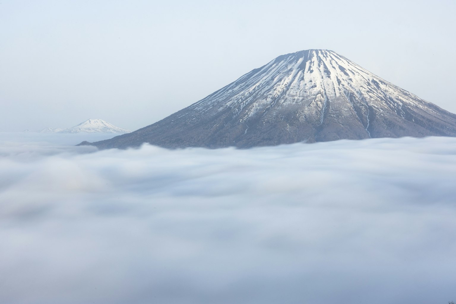 Snow-capped mountain towering above the clouds