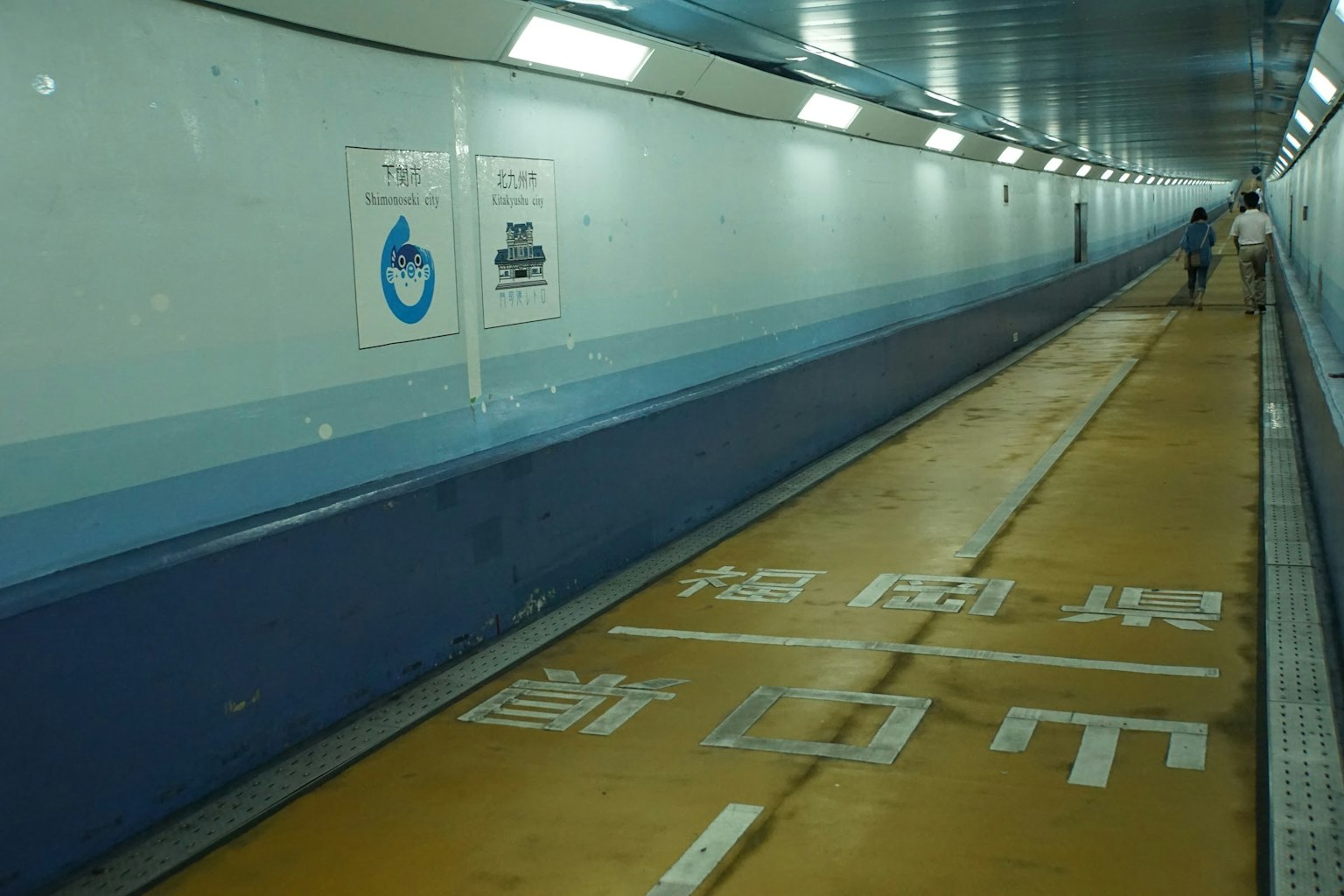 行人隧道内部，蓝色墙壁和黄色地板