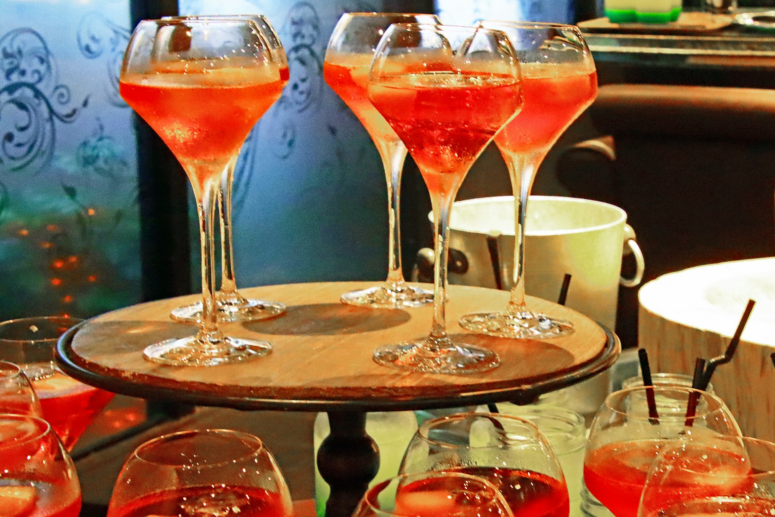 Bicchieri pieni di cocktail rossi su un vassoio di legno