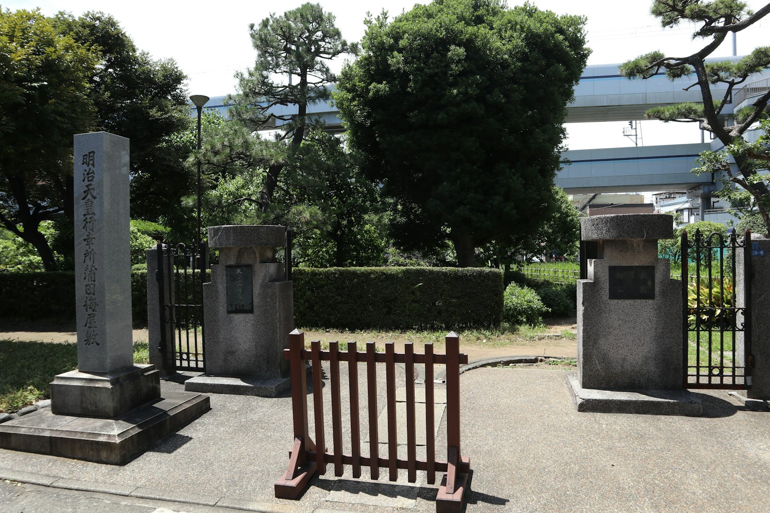 Paesaggio con monumenti in pietra e recinzione in legno in un parco
