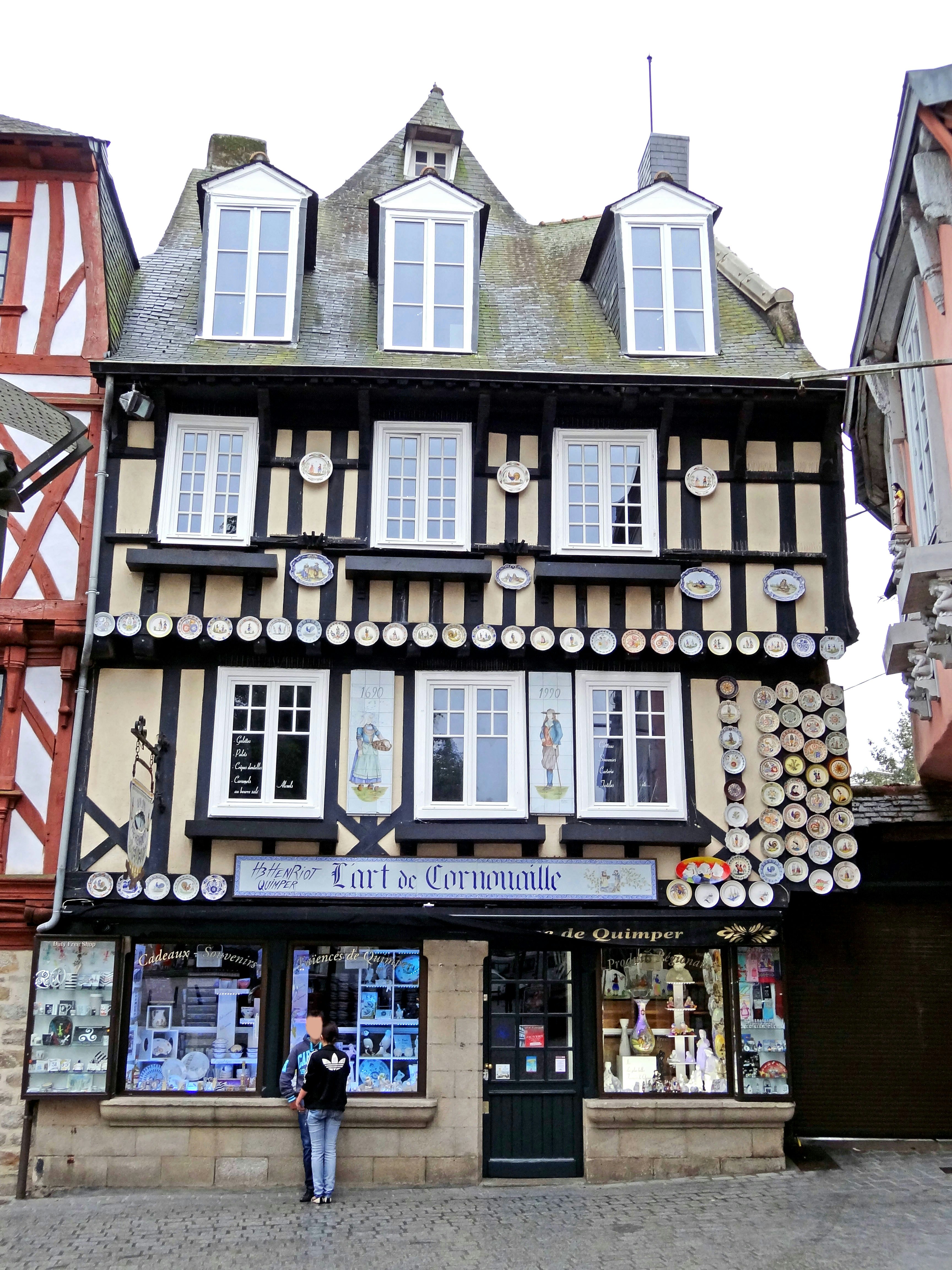 façade de boutique sur une rue avec bâtiment à colombages et décorations de fenêtres rondes